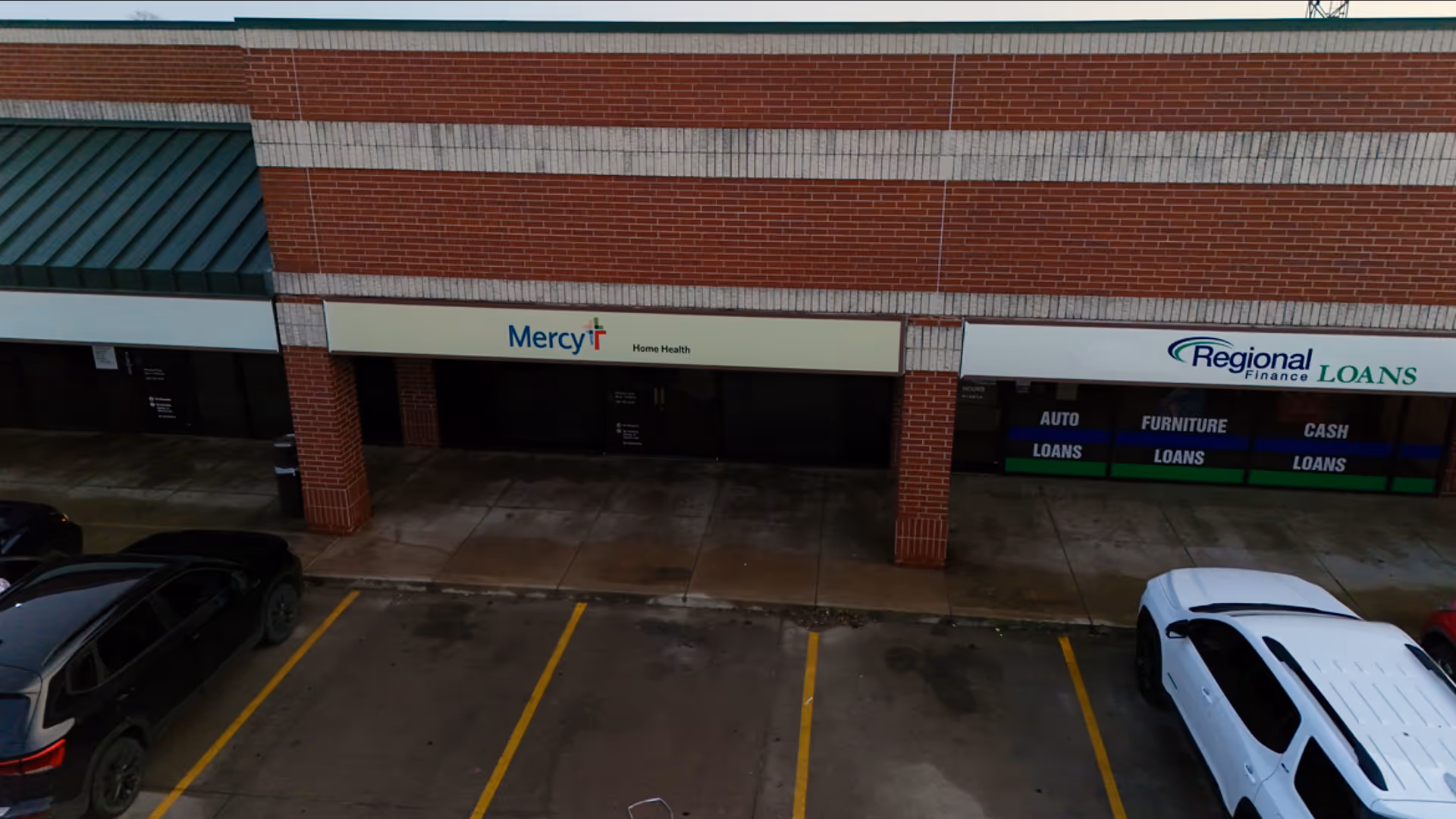 Exterior view of a strip mall with Mercy Home Health Ardmore sign and parked cars.
