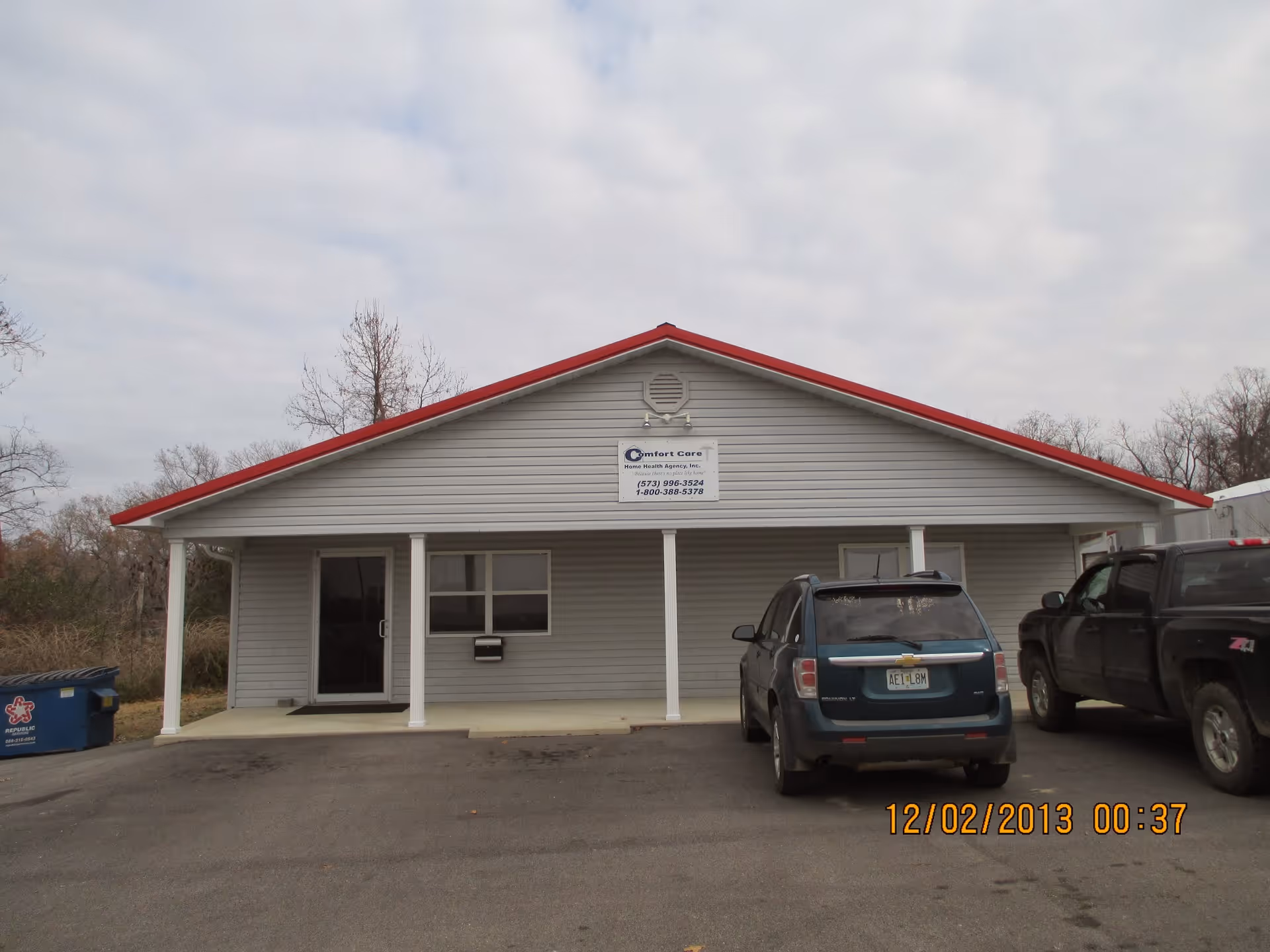 Front view of Comfort Care Home Health Agency building with two cars in the parking lot.
