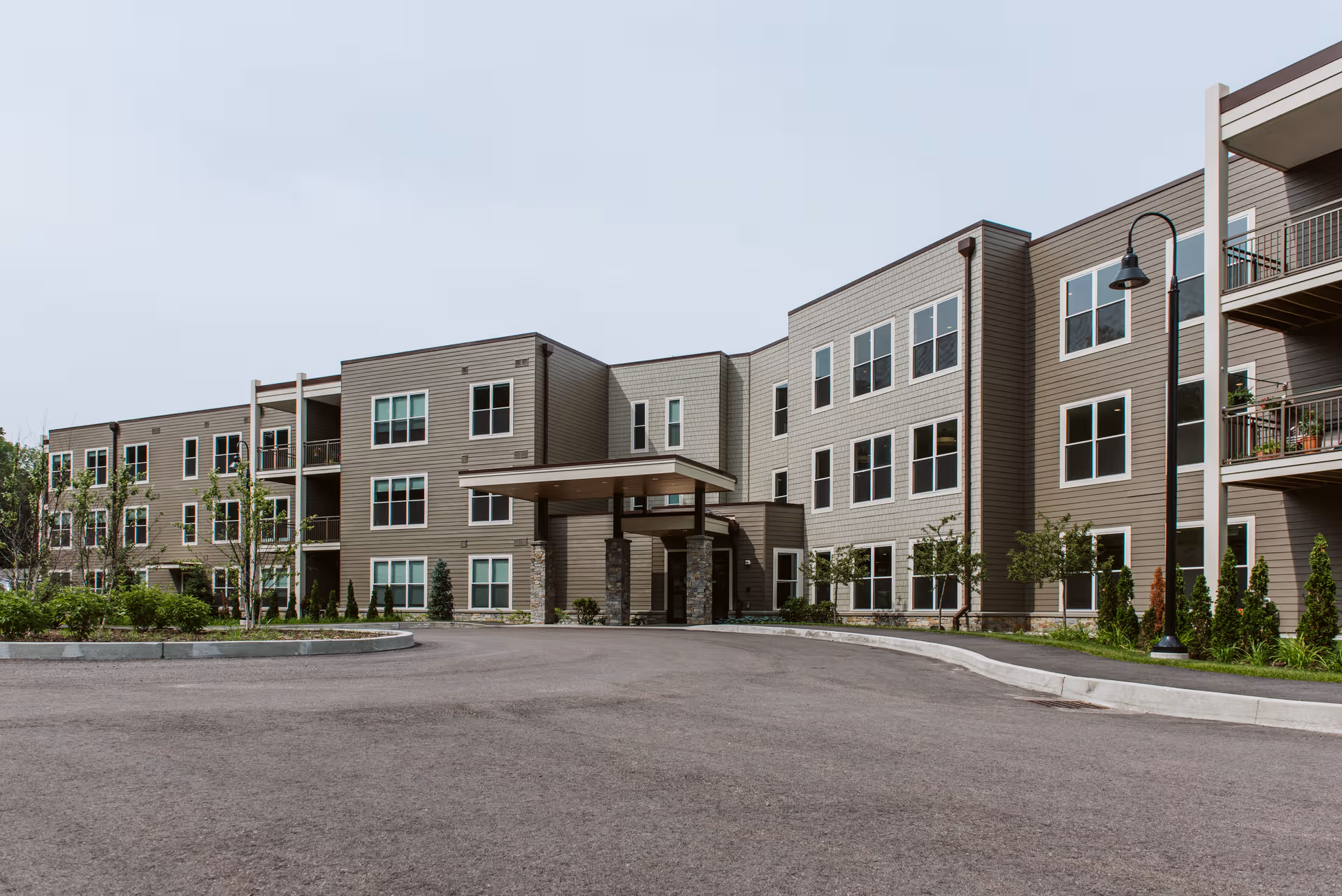 Exterior view of Wake Robin Life Plan Retirement Community building with entrance and driveway.