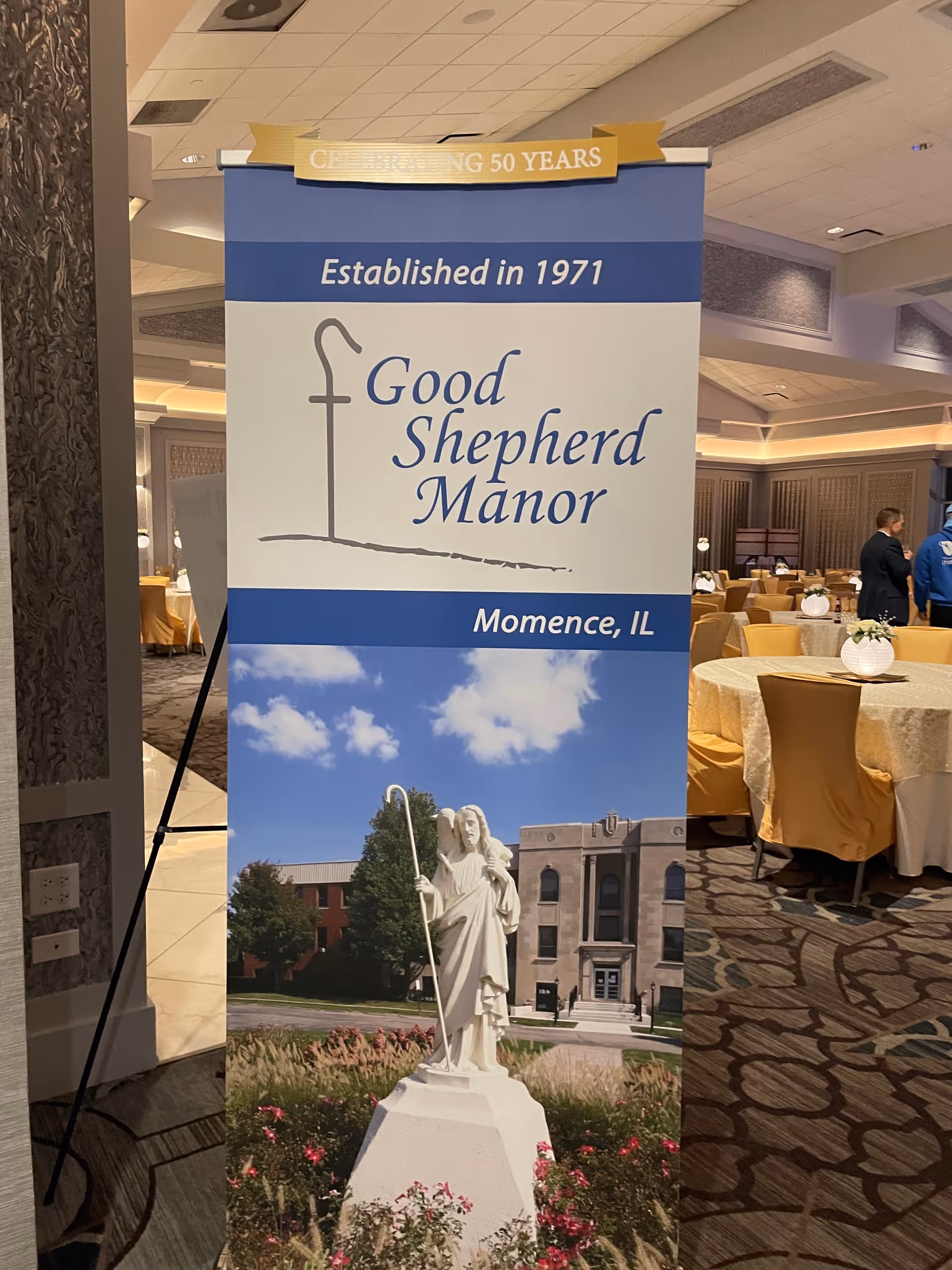 Indoor banquet hall with a tall banner for Good Shepherd Manor in Momence, IL.