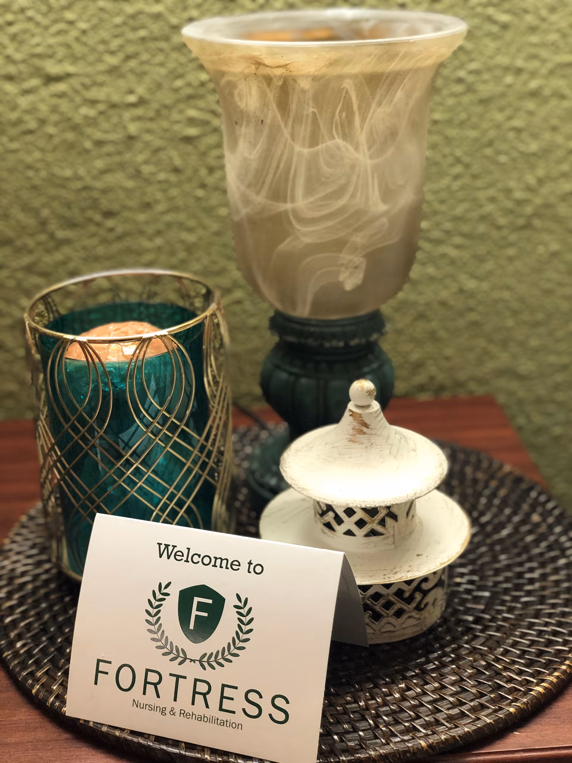 Close-up of a decorative table with a welcome card for Fortress Nursing and Rehabilitation.