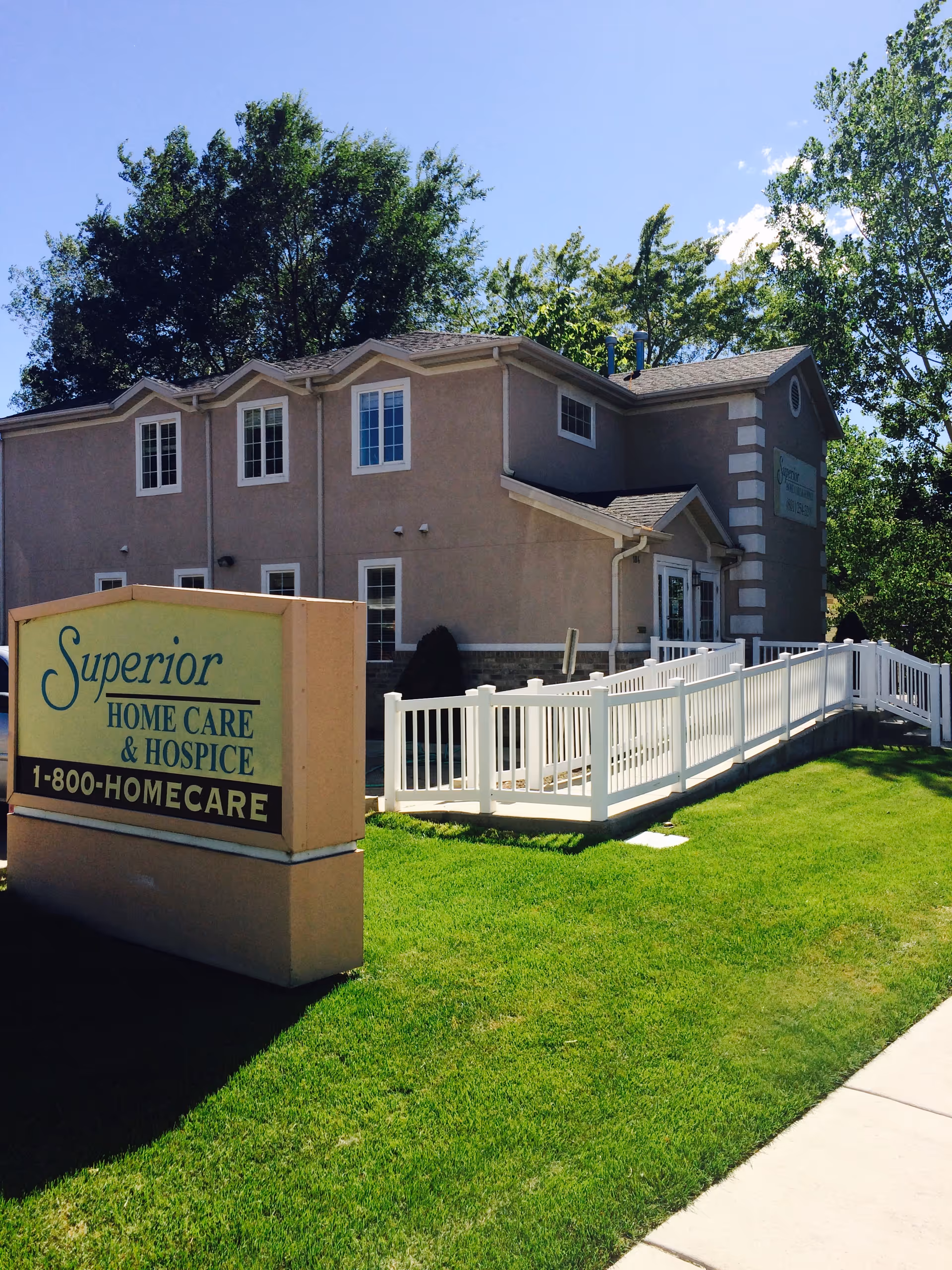 Beige senior care building with a white railing and sign reading Superior Home Care & Hospice.