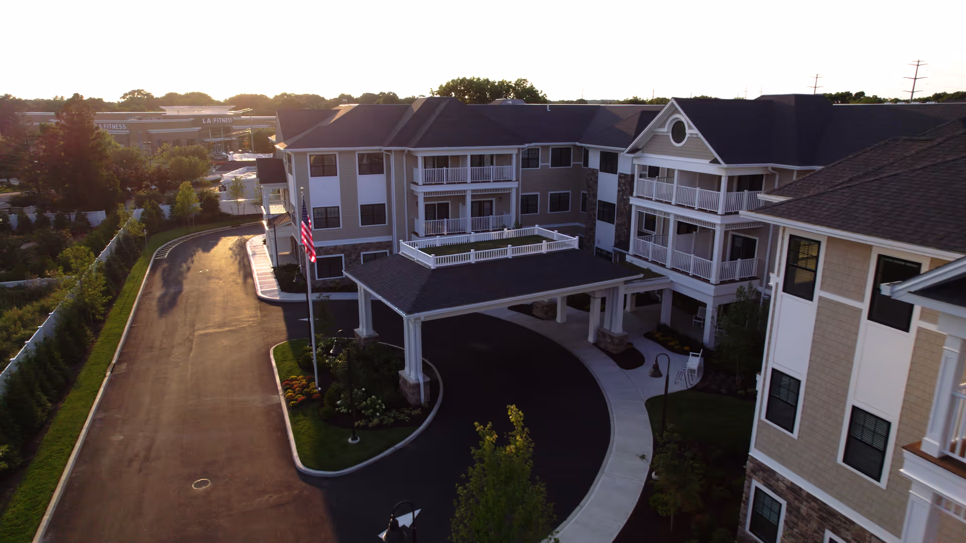 Aerial view of Brightview Port Jefferson's multi-story building with circular entrance driveway and flagpole.