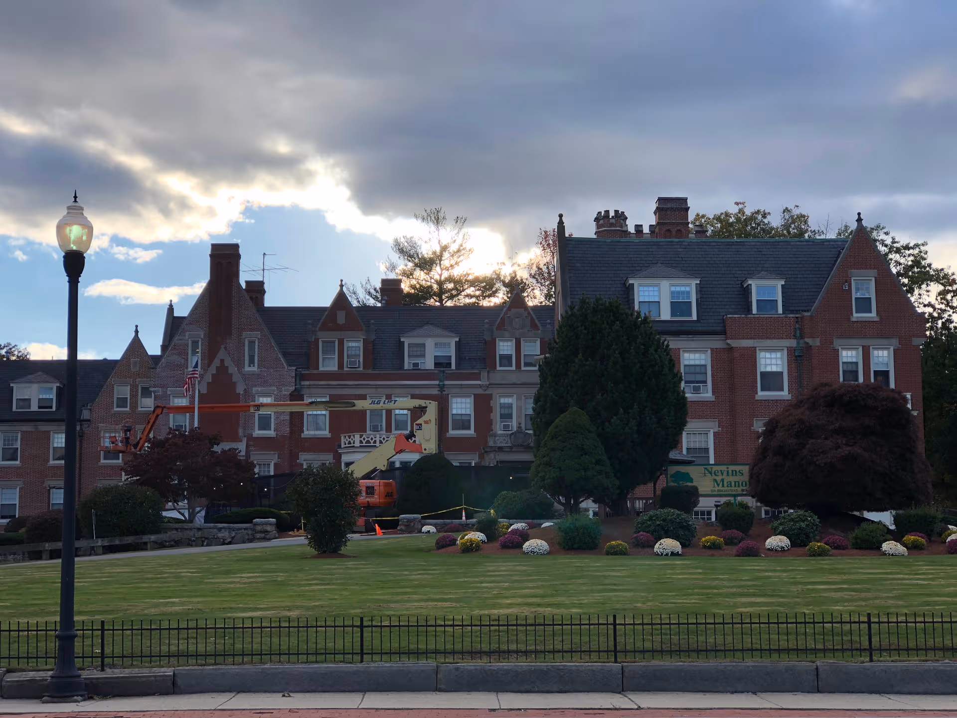 This exterior shows a brick nursing home with a landscaped lawn and sign.