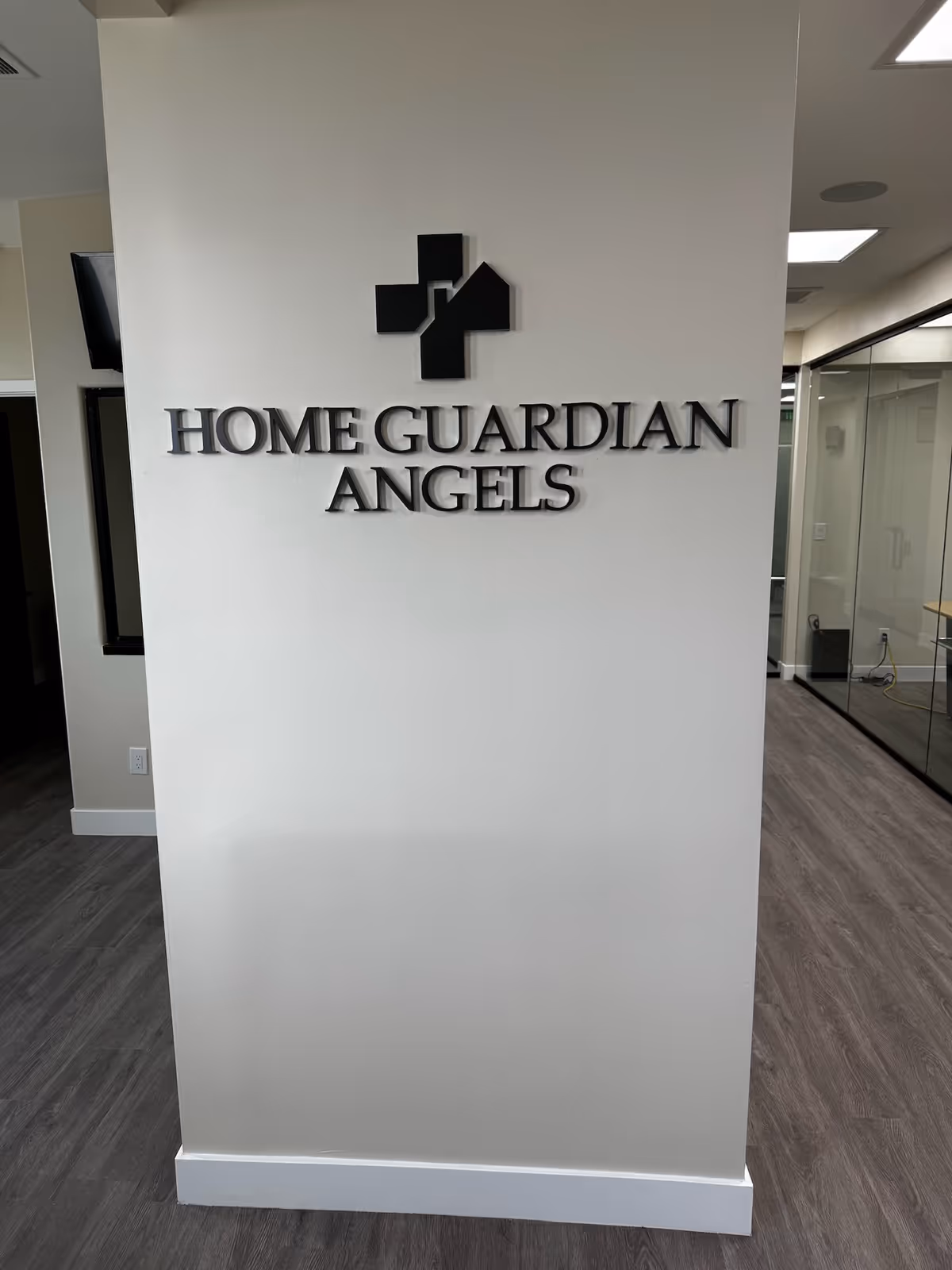 Interior wall signage displaying Home Guardian Angels with a cross logo.