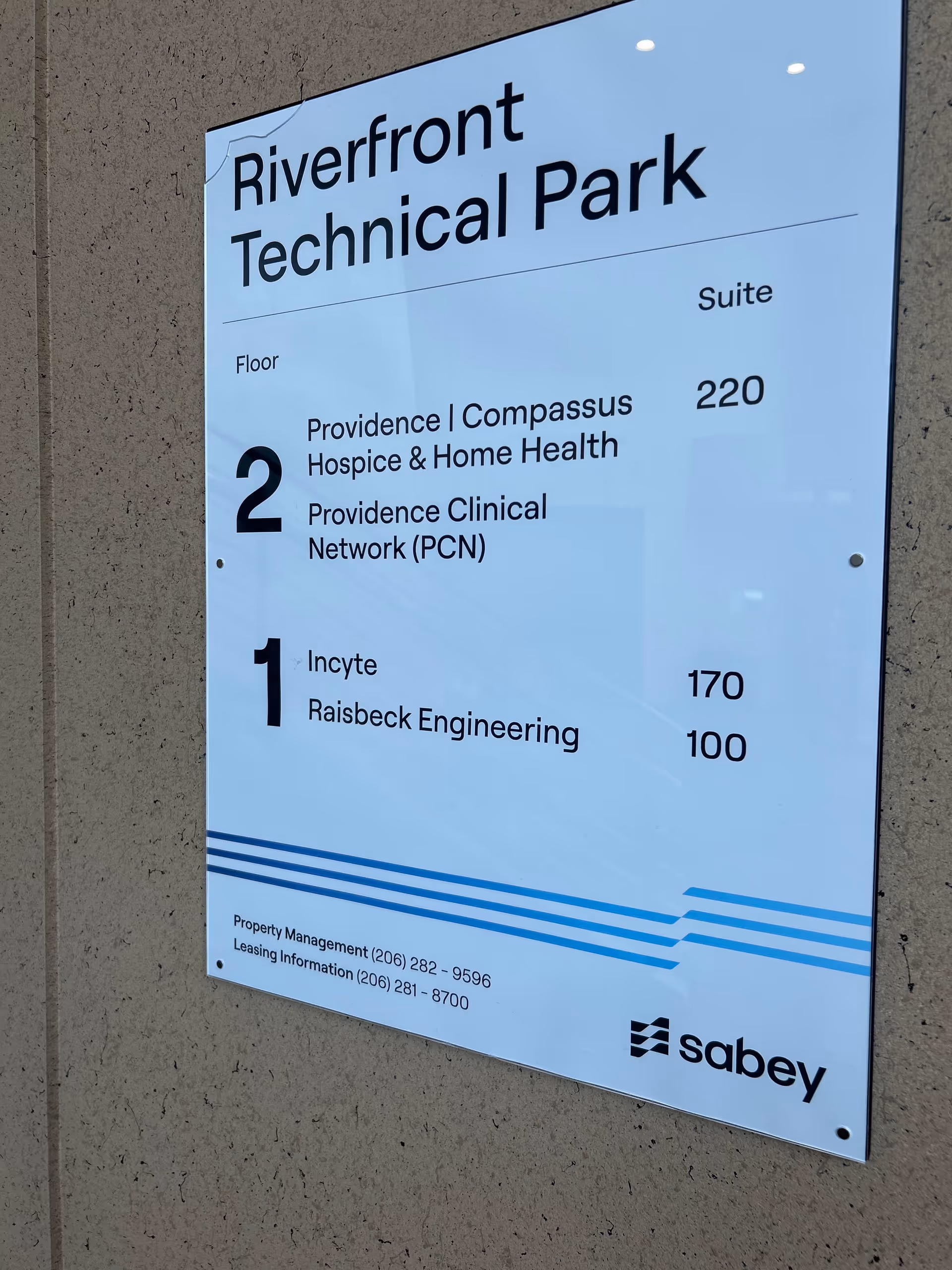Exterior wall sign displaying Riverfront Technical Park directory and suite numbers.