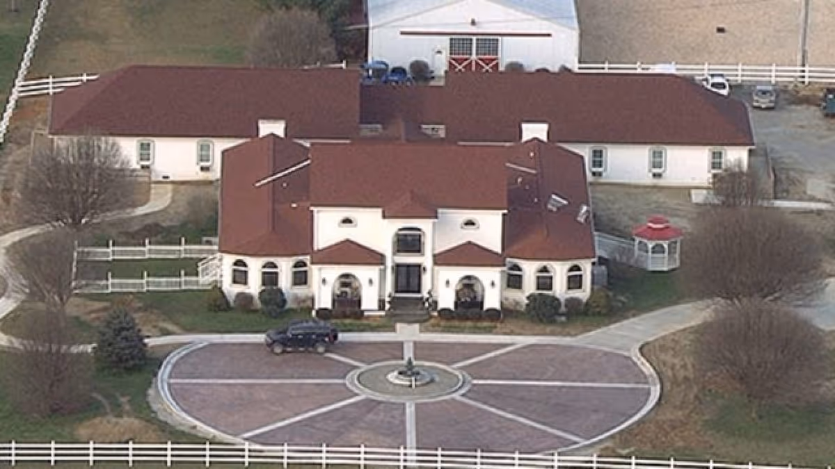 A large senior living facility with a red roof and circular front drive.