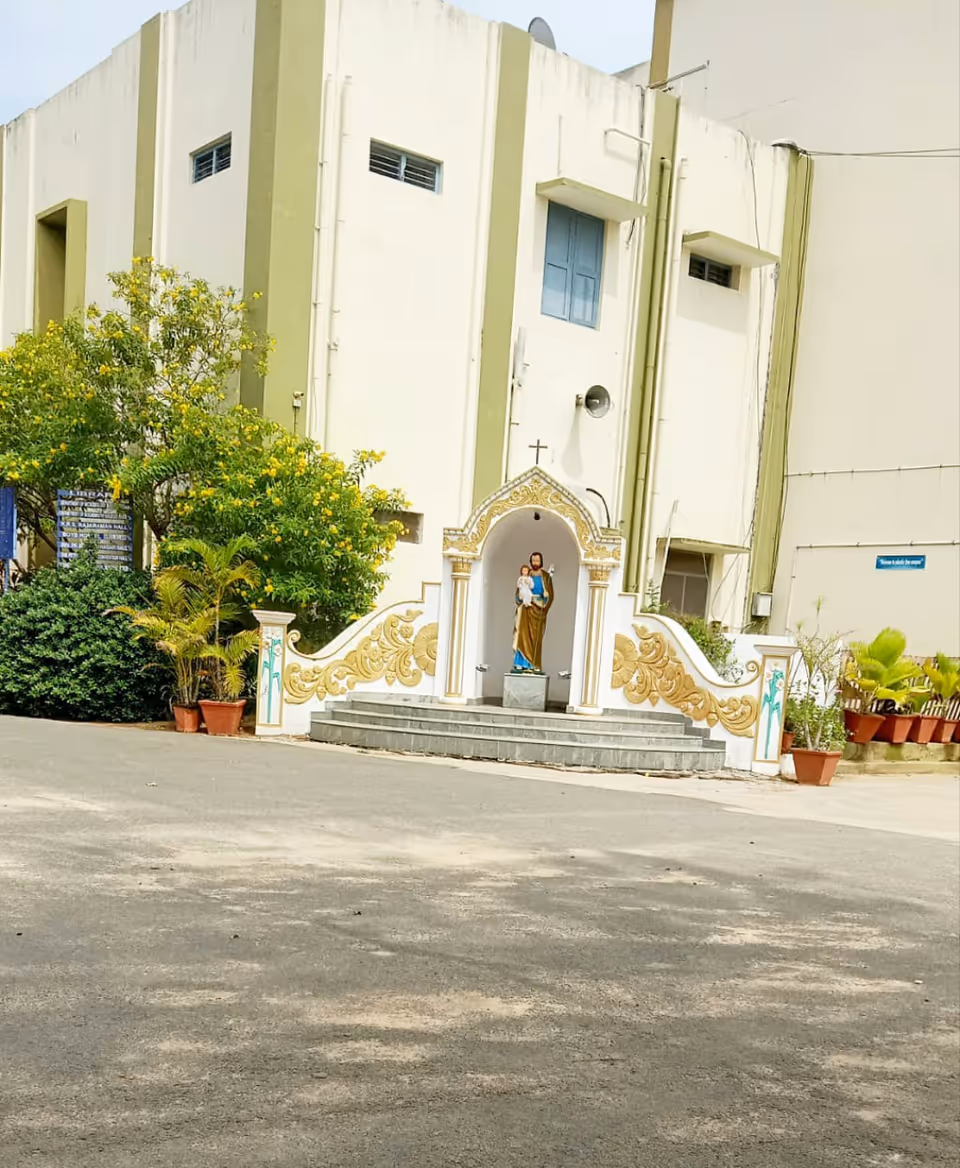 Exterior view of St. Joseph's Hospital Skilled Nursing Facility with decorative arch and statue at entrance.