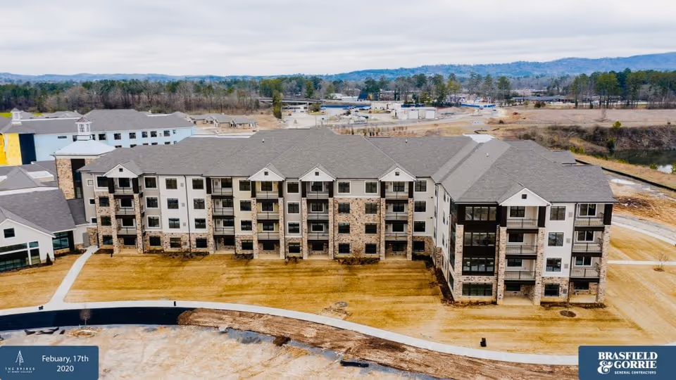Aerial front view of a multi-story senior living facility exterior with balconies.