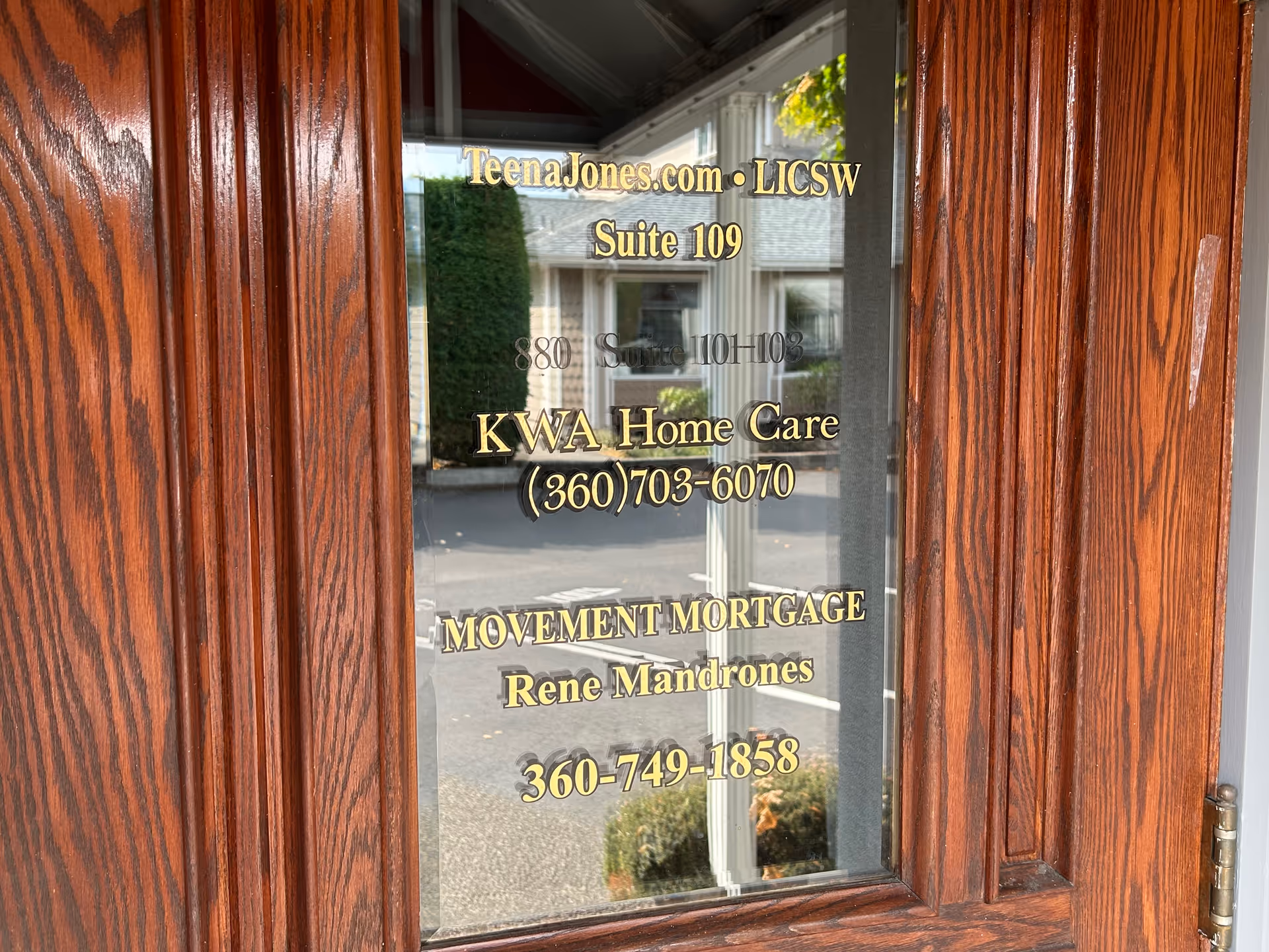 Wooden-framed glass door with gold signage for KWA Home Care and others.