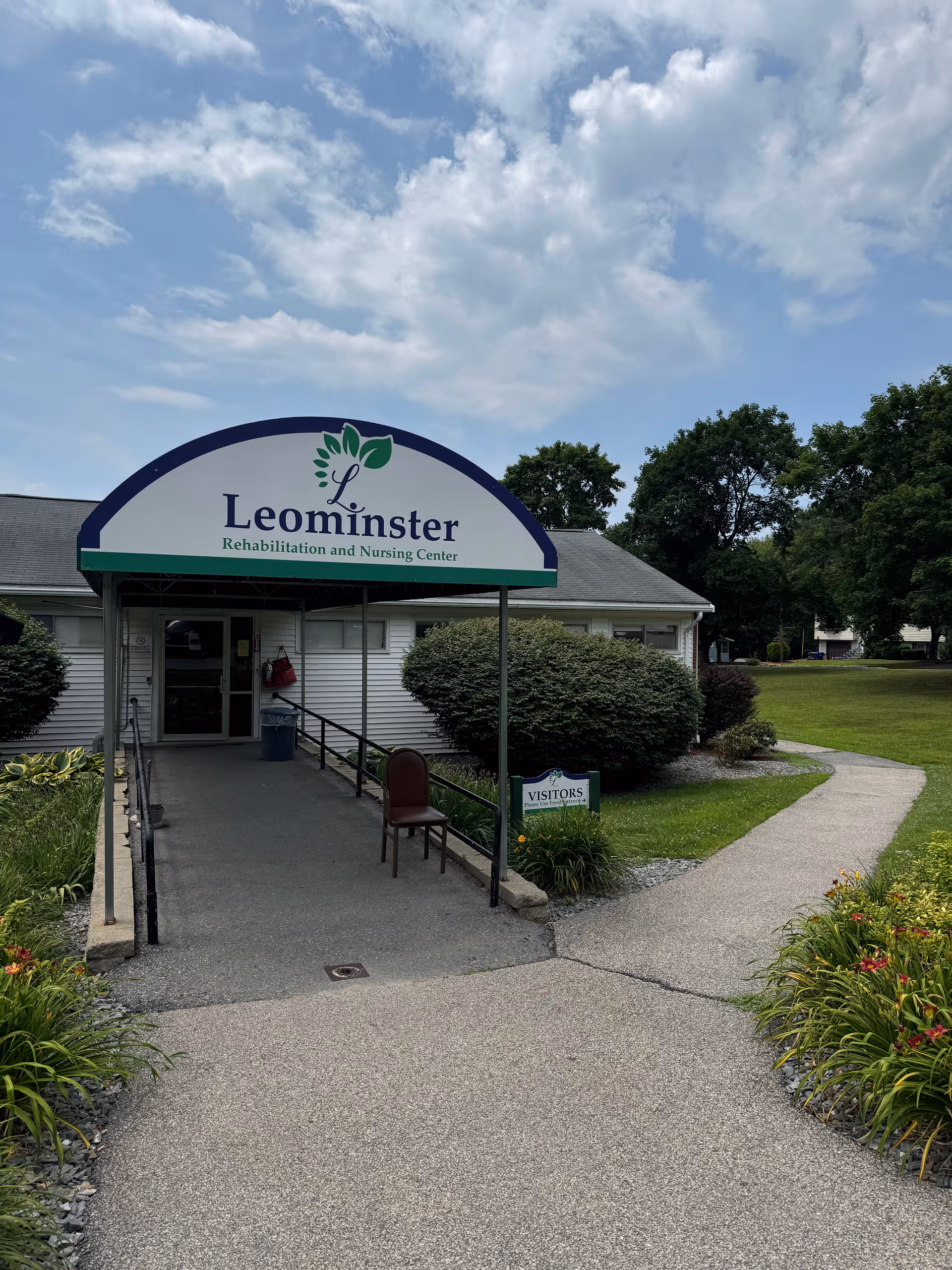 Front view of Leominster Rehabilitation and Nursing Center entrance with sign and landscaping