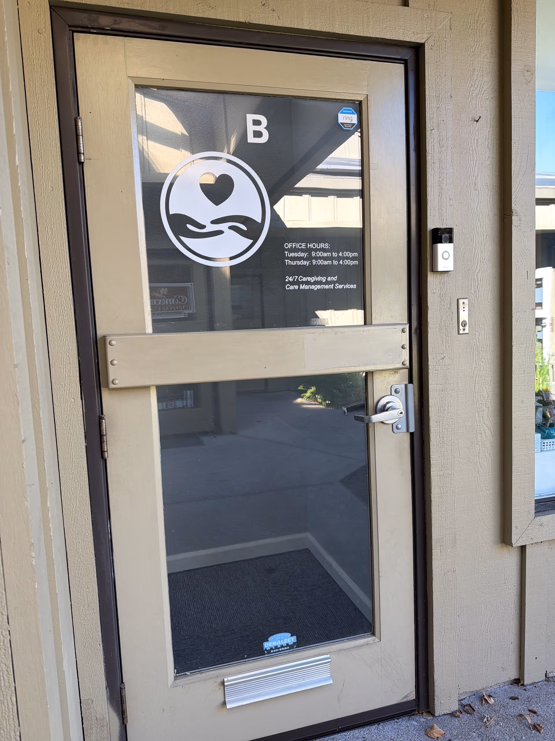 Exterior entrance door with heart logo and office hours displayed