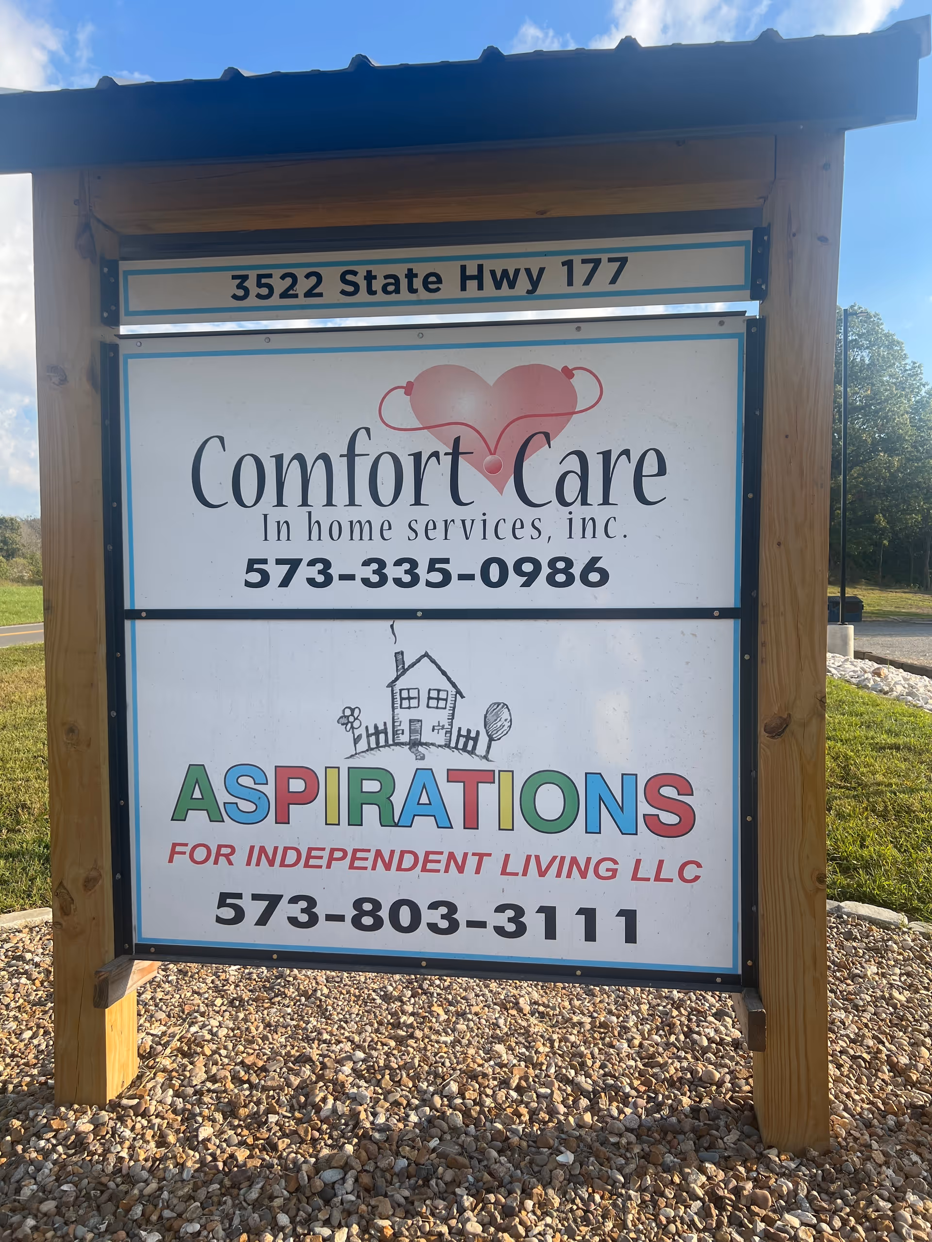 Wood-framed outdoor sign listing Comfort Care and Aspirations for Independent Living LLC.
