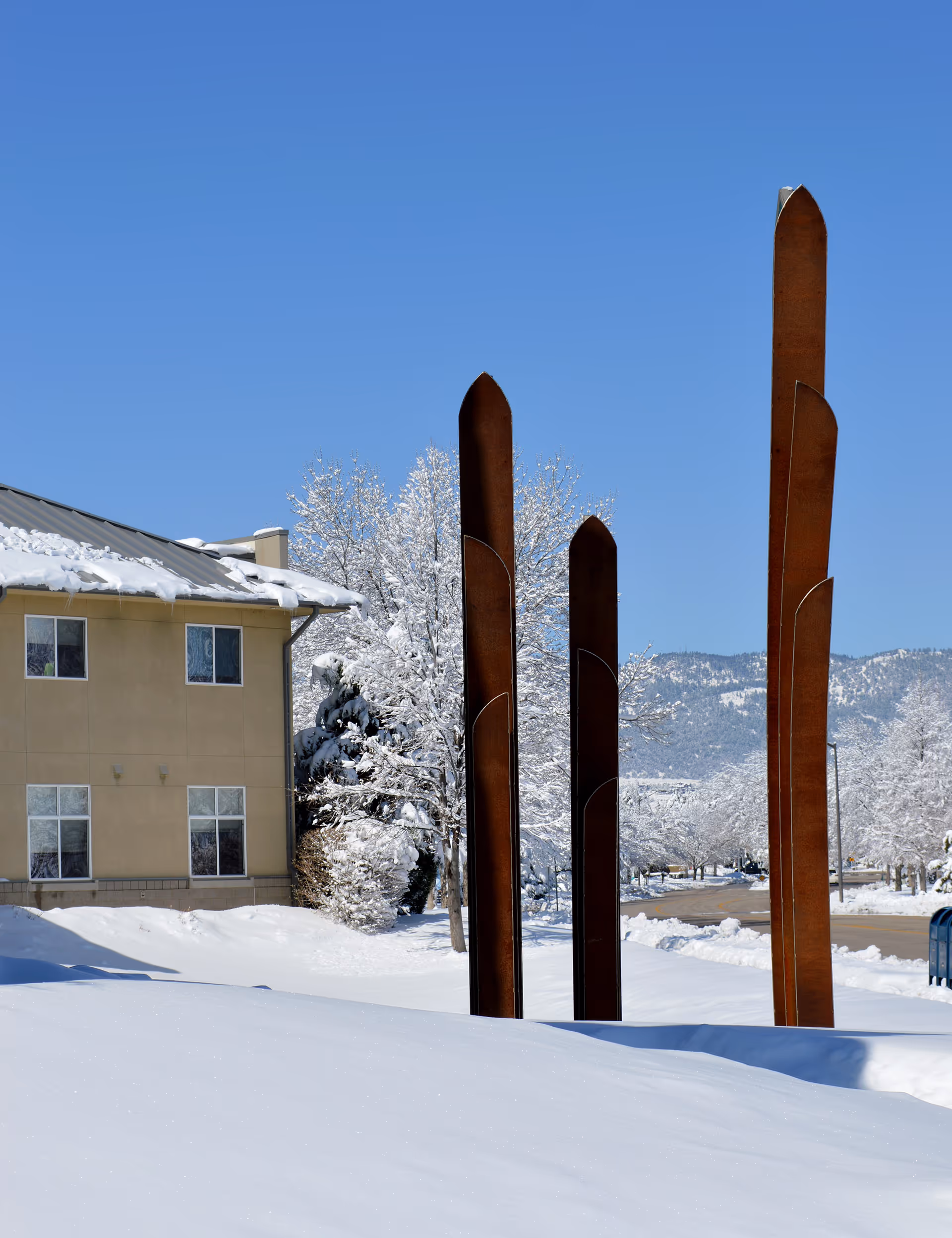 Snowy exterior of a Columbine Health Systems campus with tall rust-colored sculpture pillars.