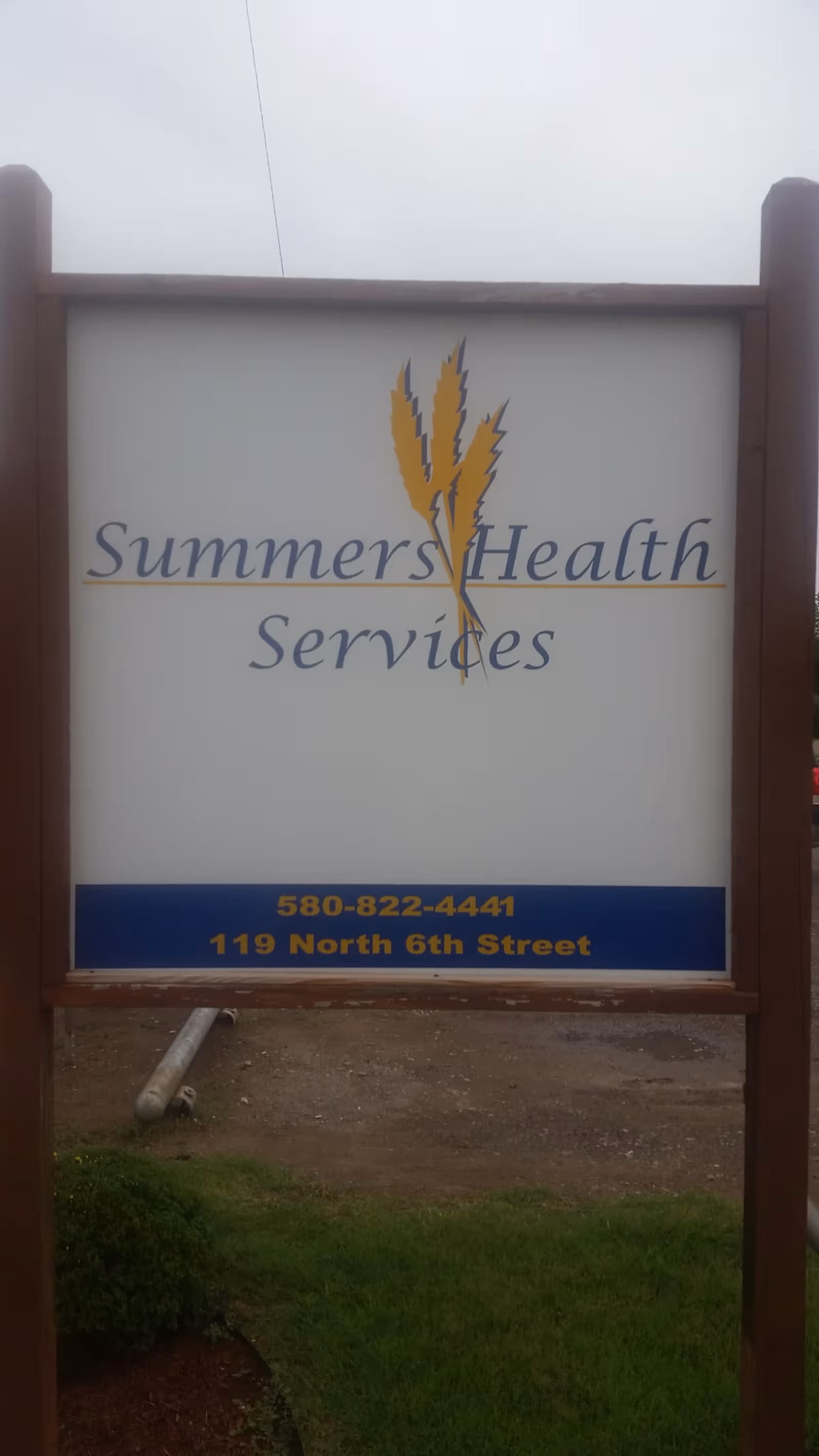 Outdoor sign for Summers Health Services with a yellow wheat logo.