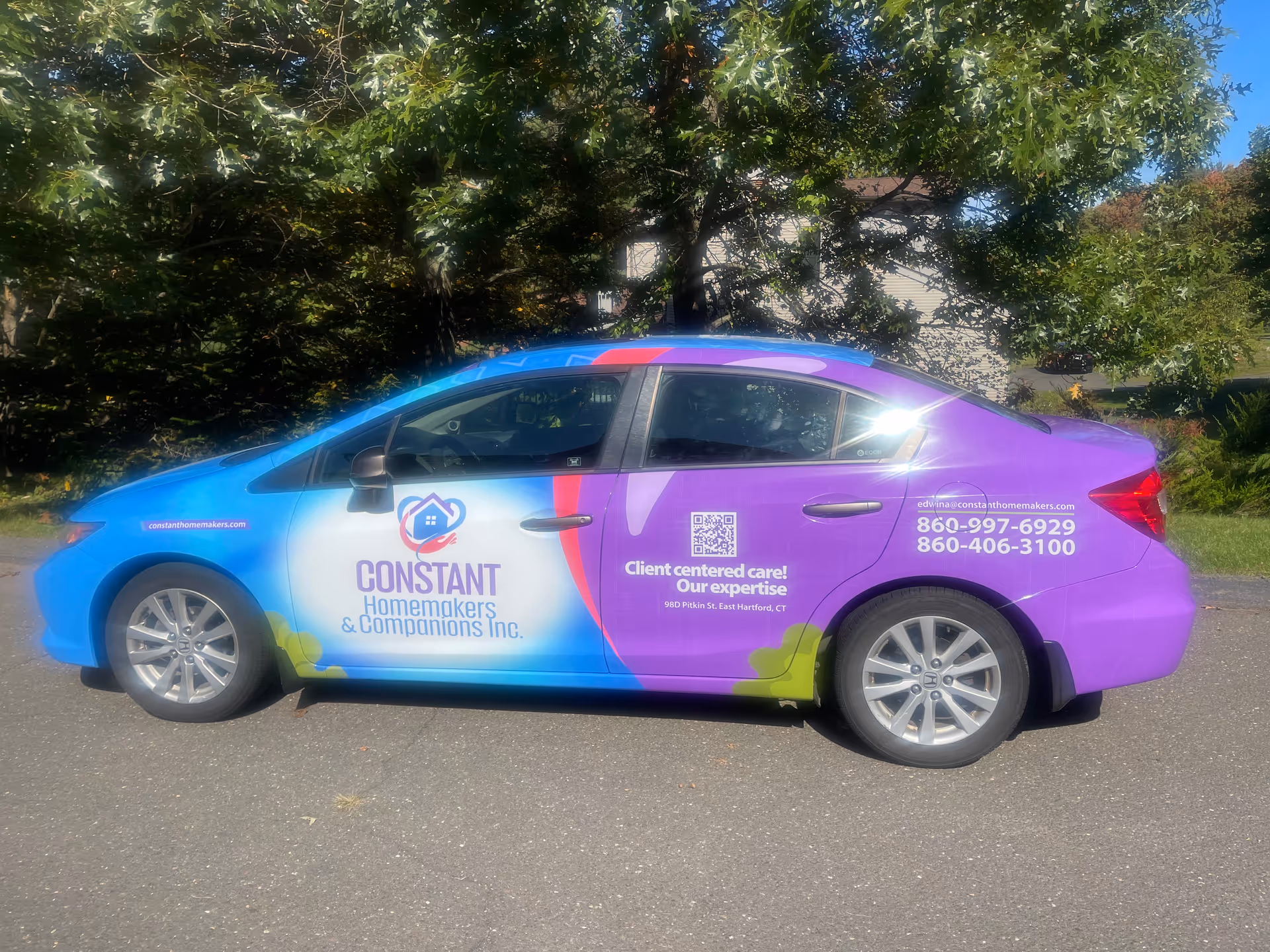 Colorful branded van for Constant Homemakers & Companions Inc. parked on a residential street.