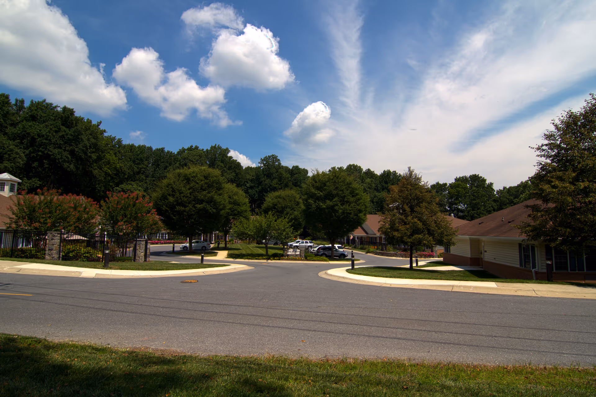 Exterior view of Meadows 1639 senior living campus with trees and curved driveway.