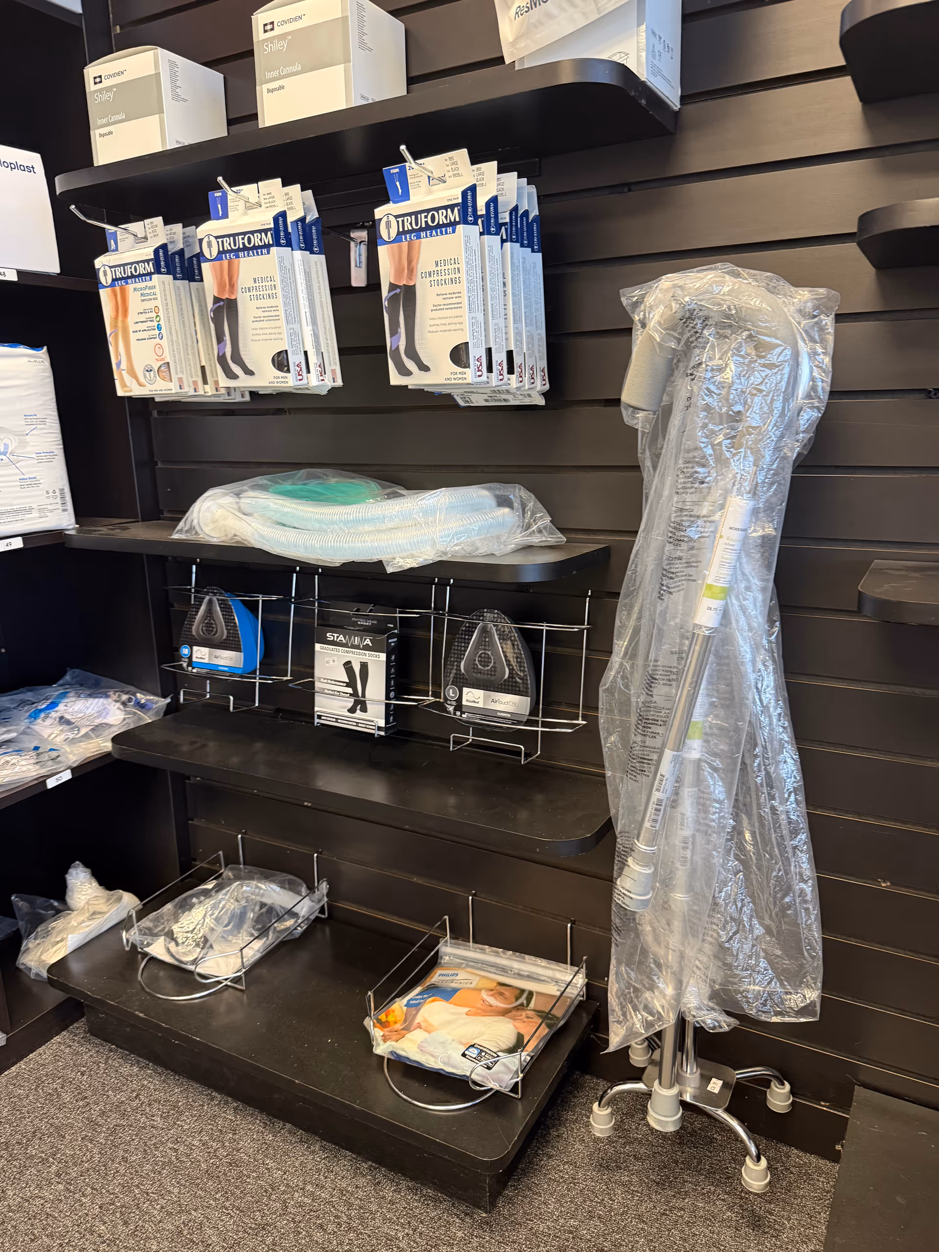 Medical equipment display on a wall, featuring packaged supplies and a wrapped IV pole.