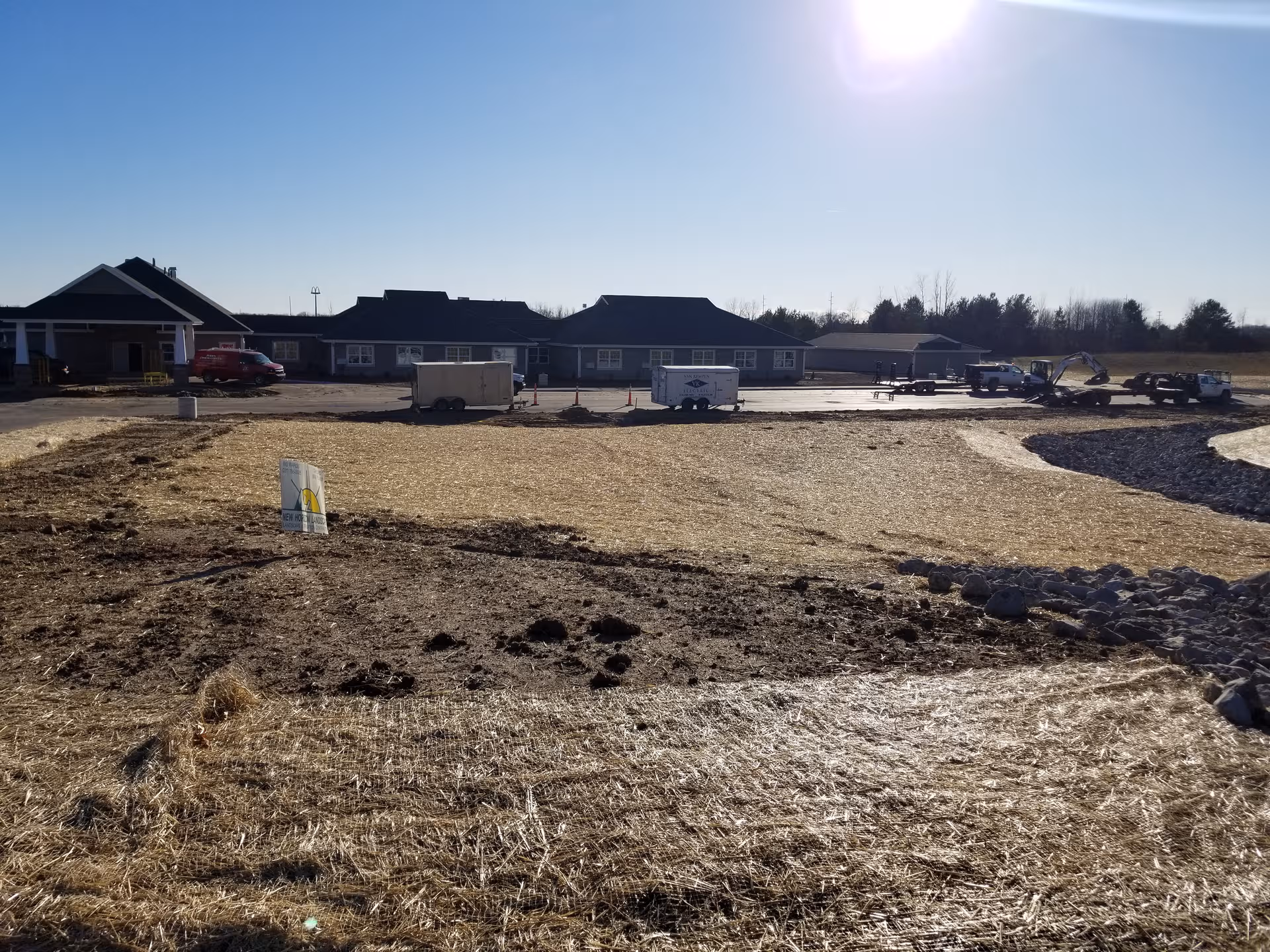 Front view of The Brook of Cedar Springs under construction with trailers and equipment.