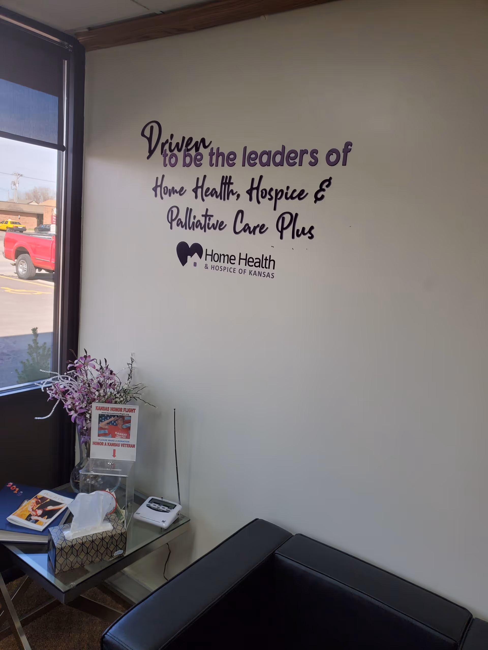 Lobby seating area featuring wall slogan and Home Health & Hospice of Kansas branding.