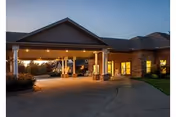 Exterior view of Shiloh Nursing and Rehab facility entrance with a lit covered driveway.