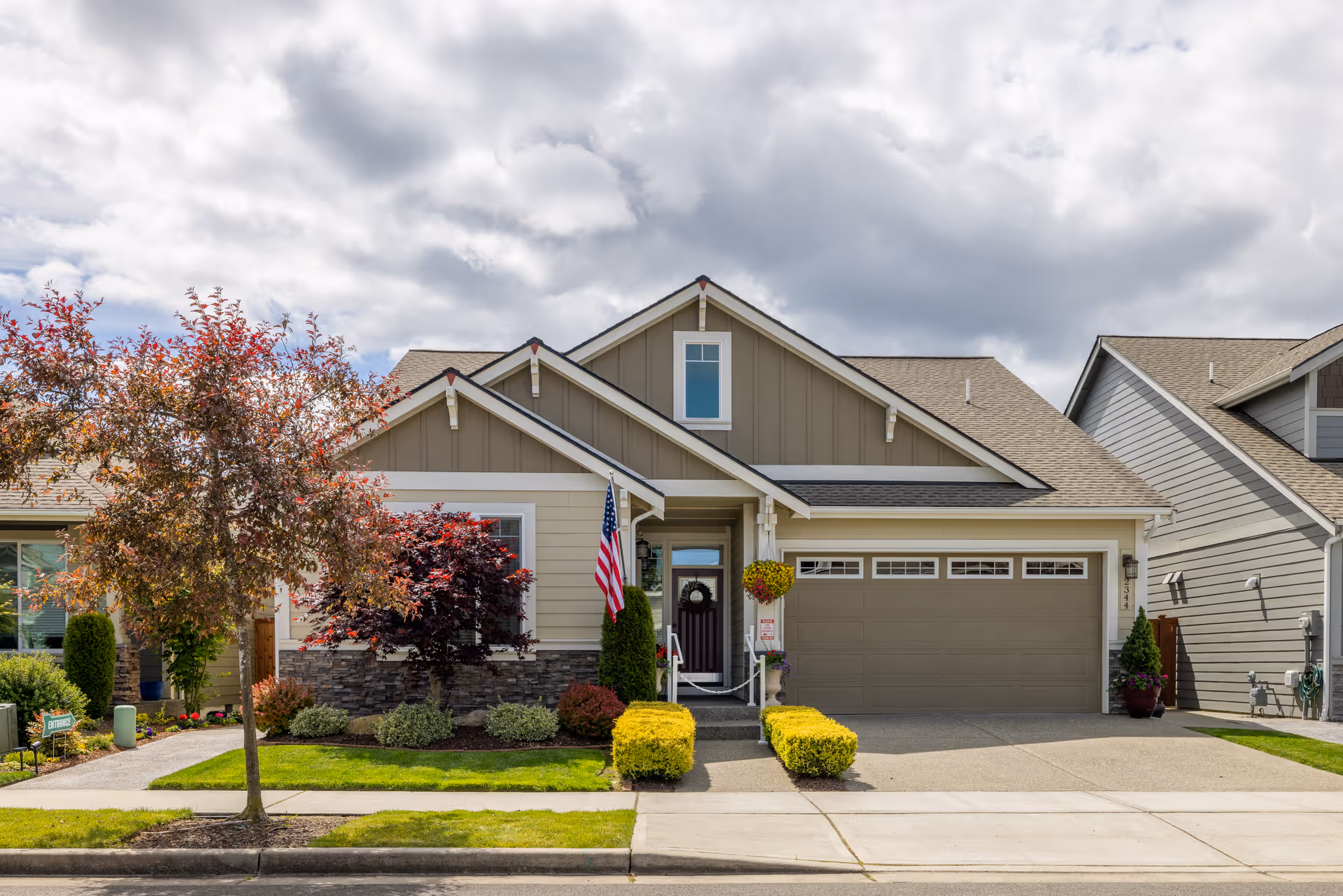 Front exterior of a single-story home with landscaped yard and American flag.
