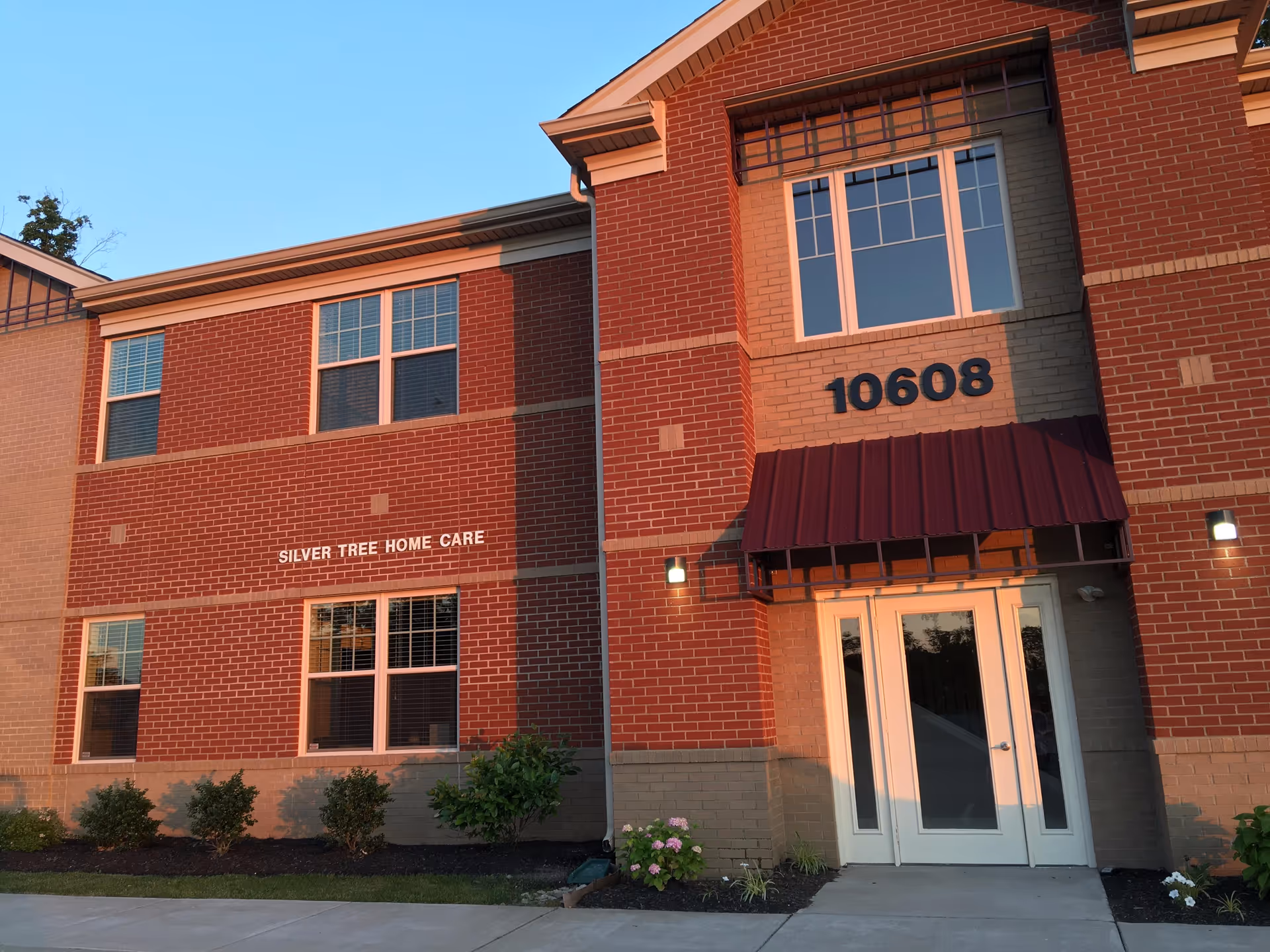 Brick building with front entrance and a sign reading Silver Tree Home Care.