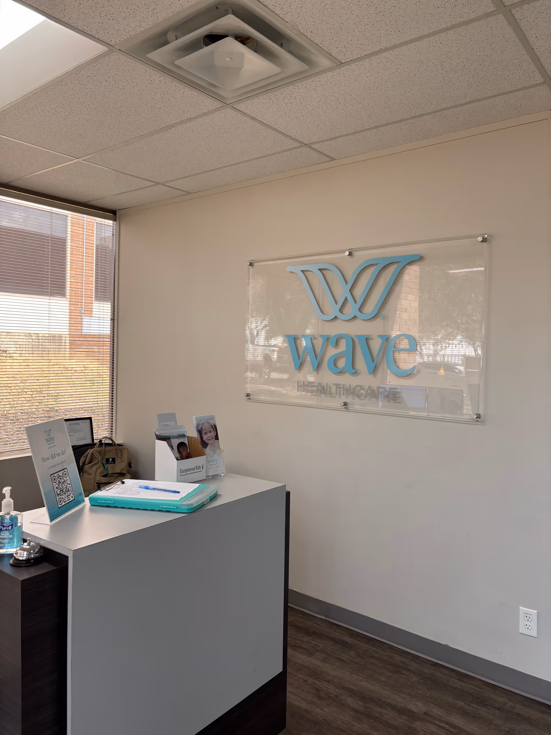 Reception desk in a Wave Healthcare lobby featuring brochures and a wall sign.