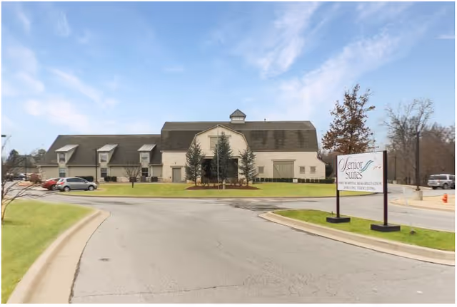 Exterior view of Senior Suites Healthcare building with curved driveway and sign.