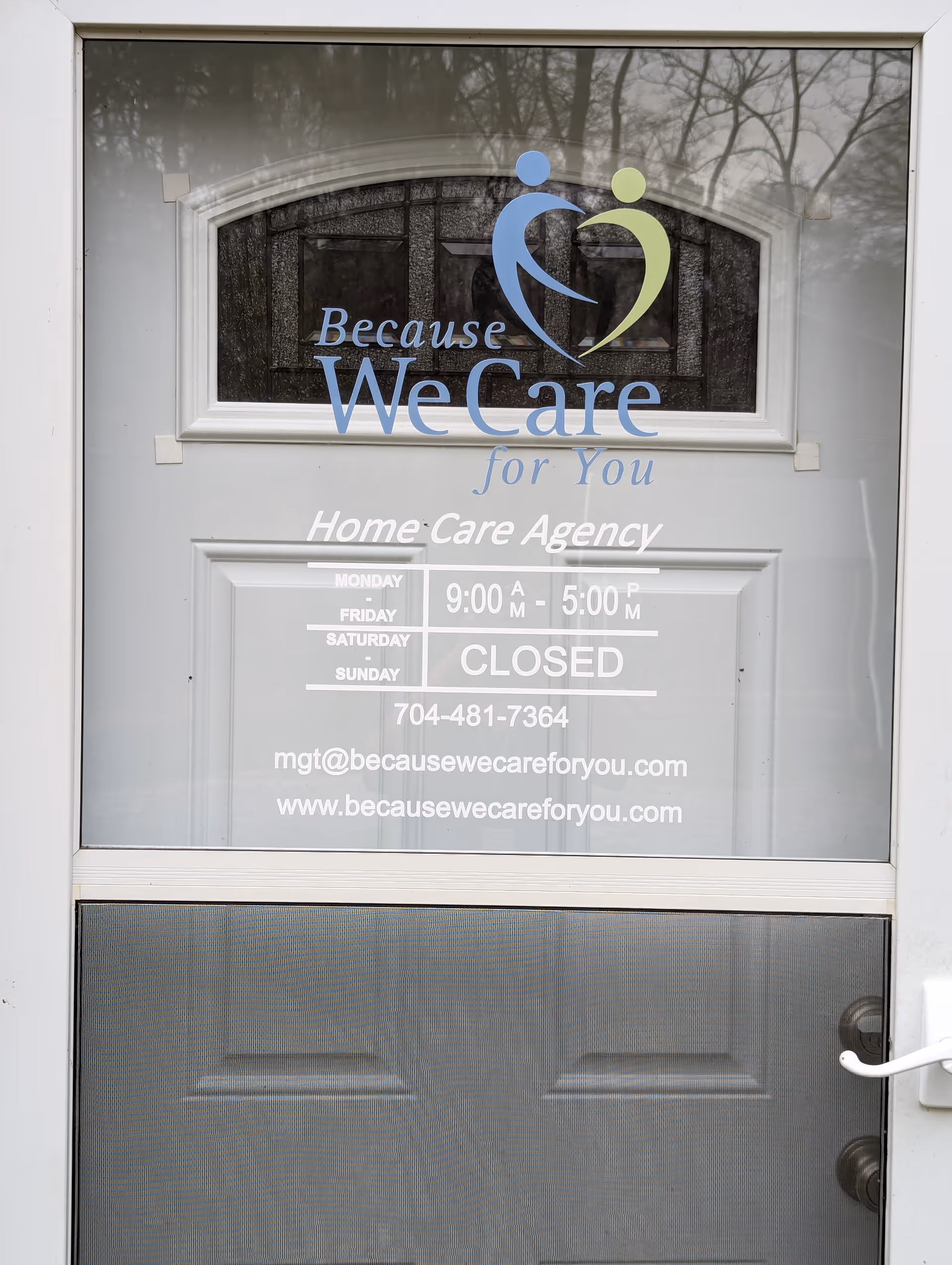 Glass front door with logo and hours for Because We Care for You Home Care Agency.