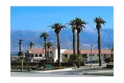 Exterior view of Stroud Health Care Center South with palm trees and a street in front.