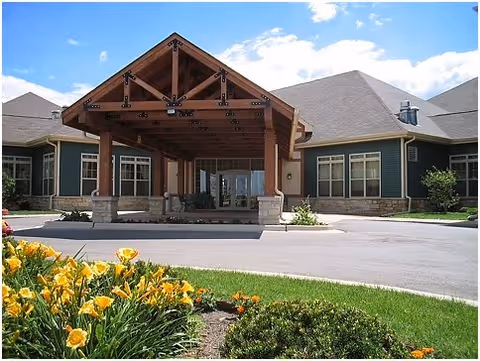 Exterior view of Timbers of Shorewood entrance with a wooden porte-cochere and landscaping