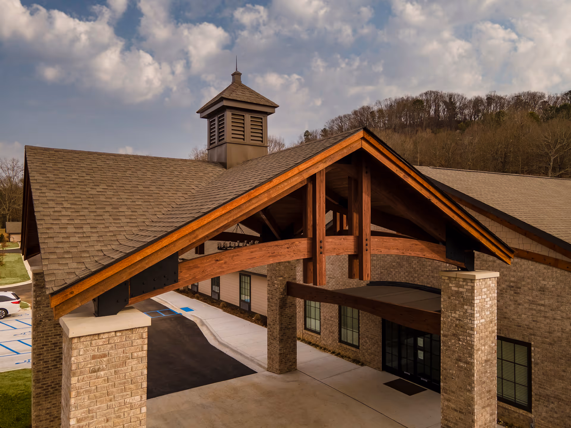 Exterior view of Lakeshore Senior Living with a wooden peaked entrance canopy.
