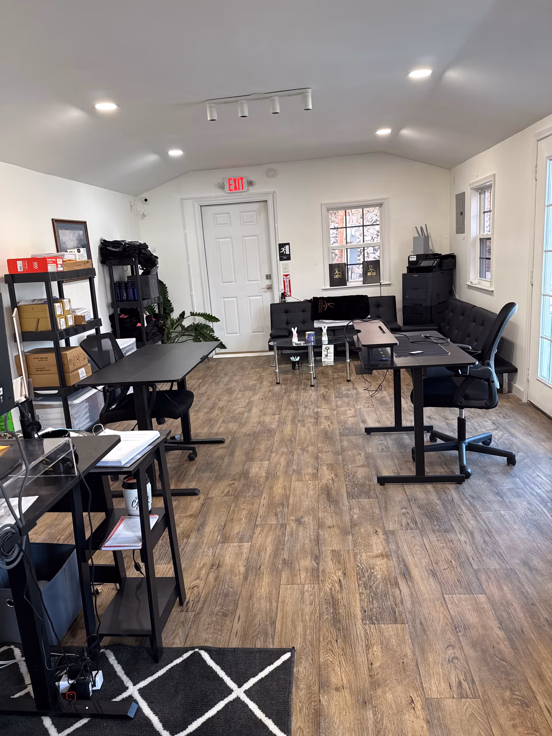 Office-like room with desks, chairs, shelves, and office equipment.