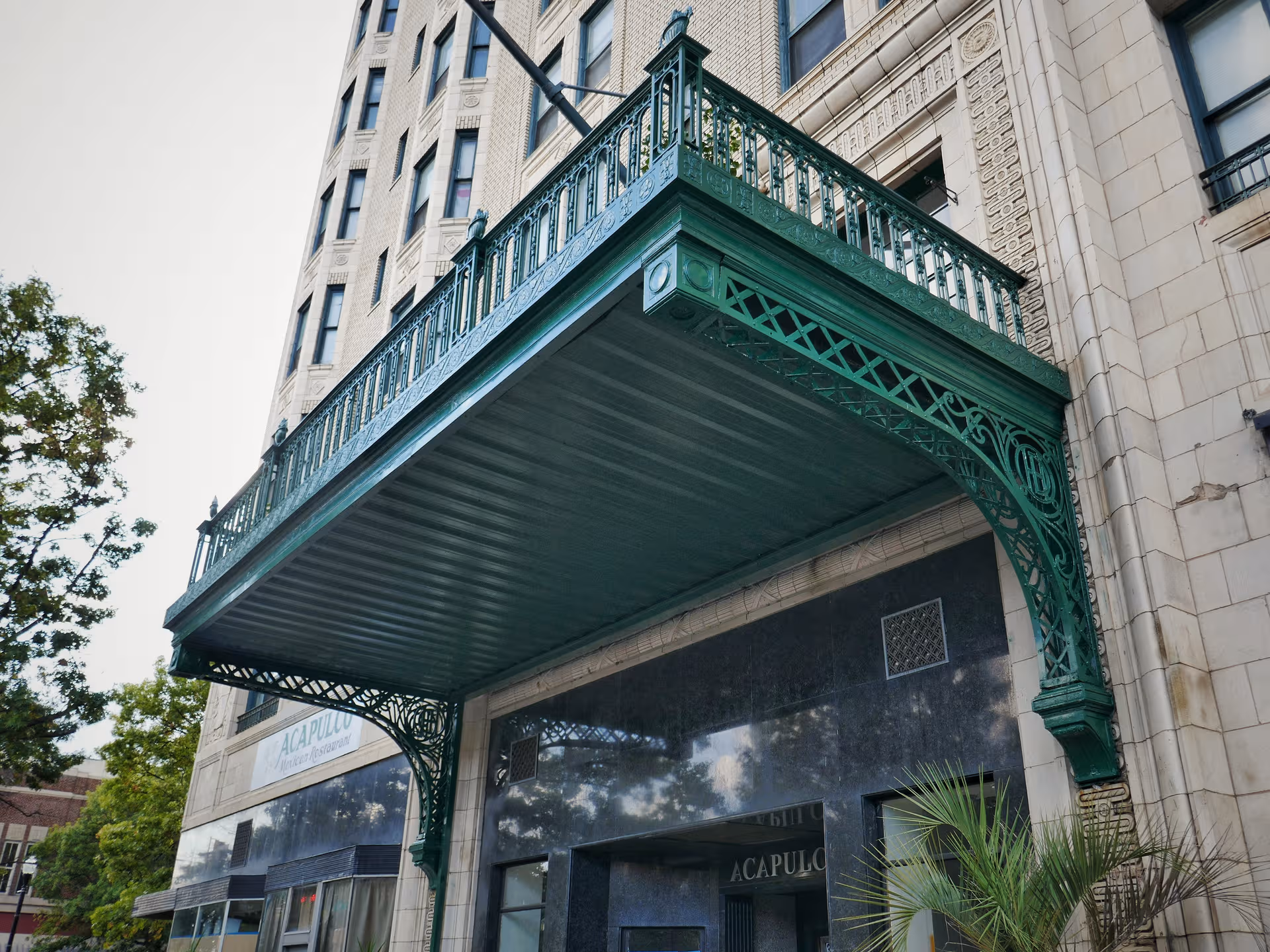 Historic building entrance with a decorative green iron canopy over the doorway.