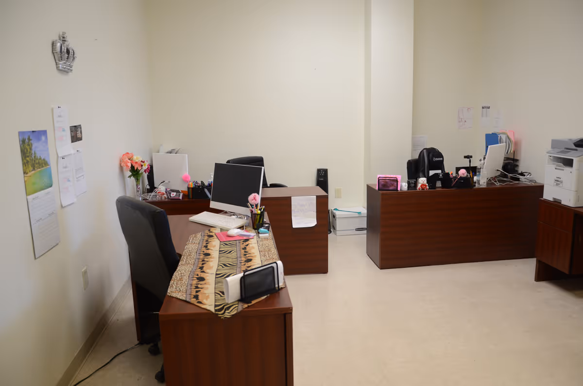 Interior office area with desks, computers, and office supplies.