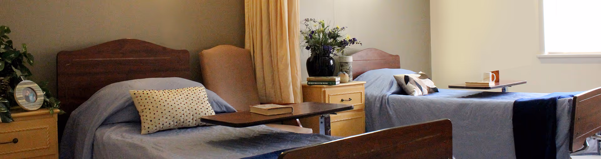 Two single beds with blue bedding and matching nightstands in a shared bedroom.