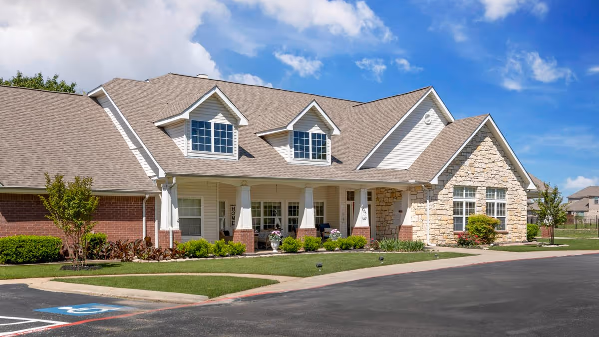 Brookdale Denton North exterior: a stone-brick senior living building with landscaped front lawn.