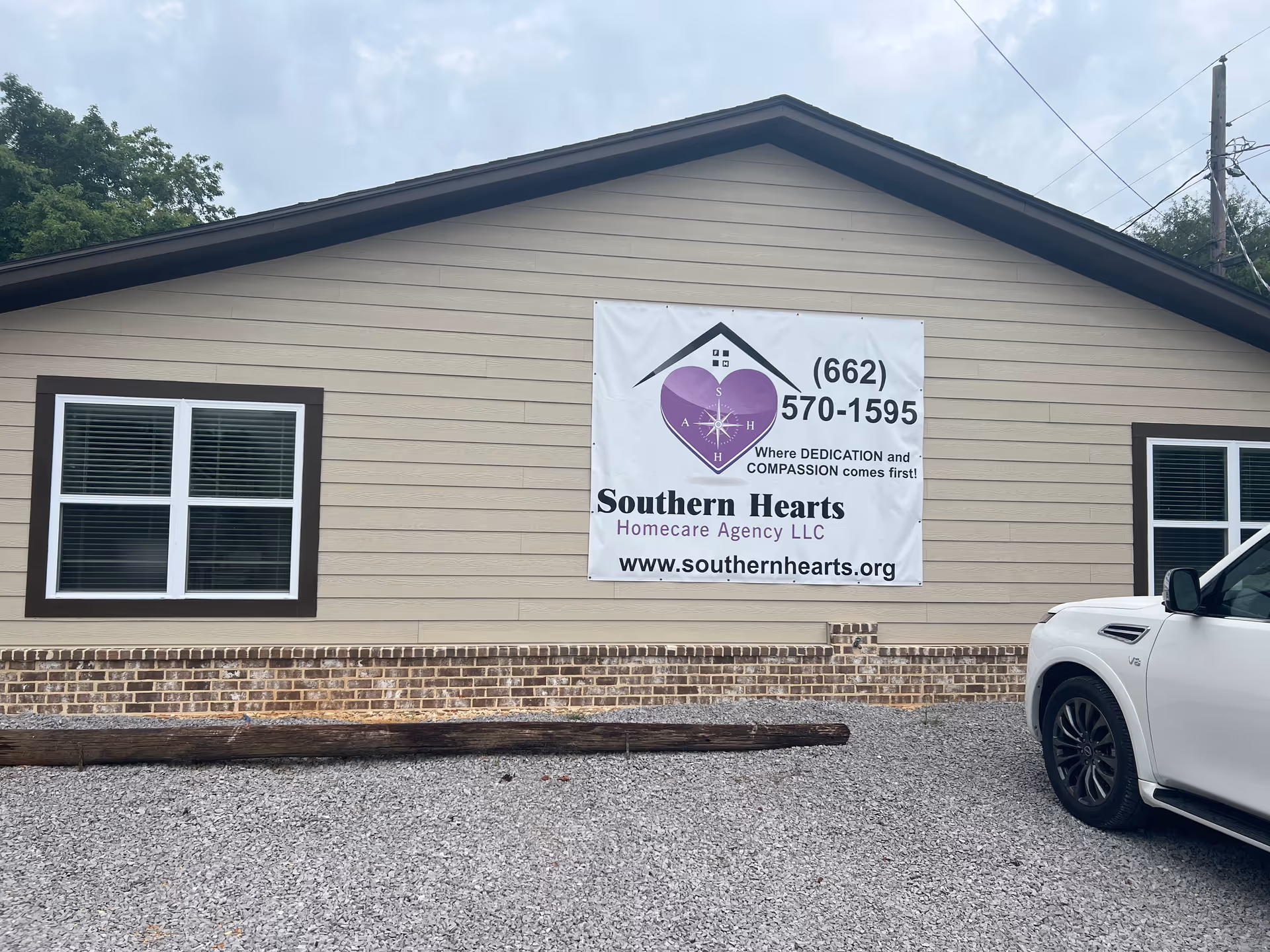 Beige, single-story building with a large Southern Hearts banner and a white car parked outside.