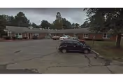 Exterior view of Latta Road Nursing Home East with cars in the parking lot.