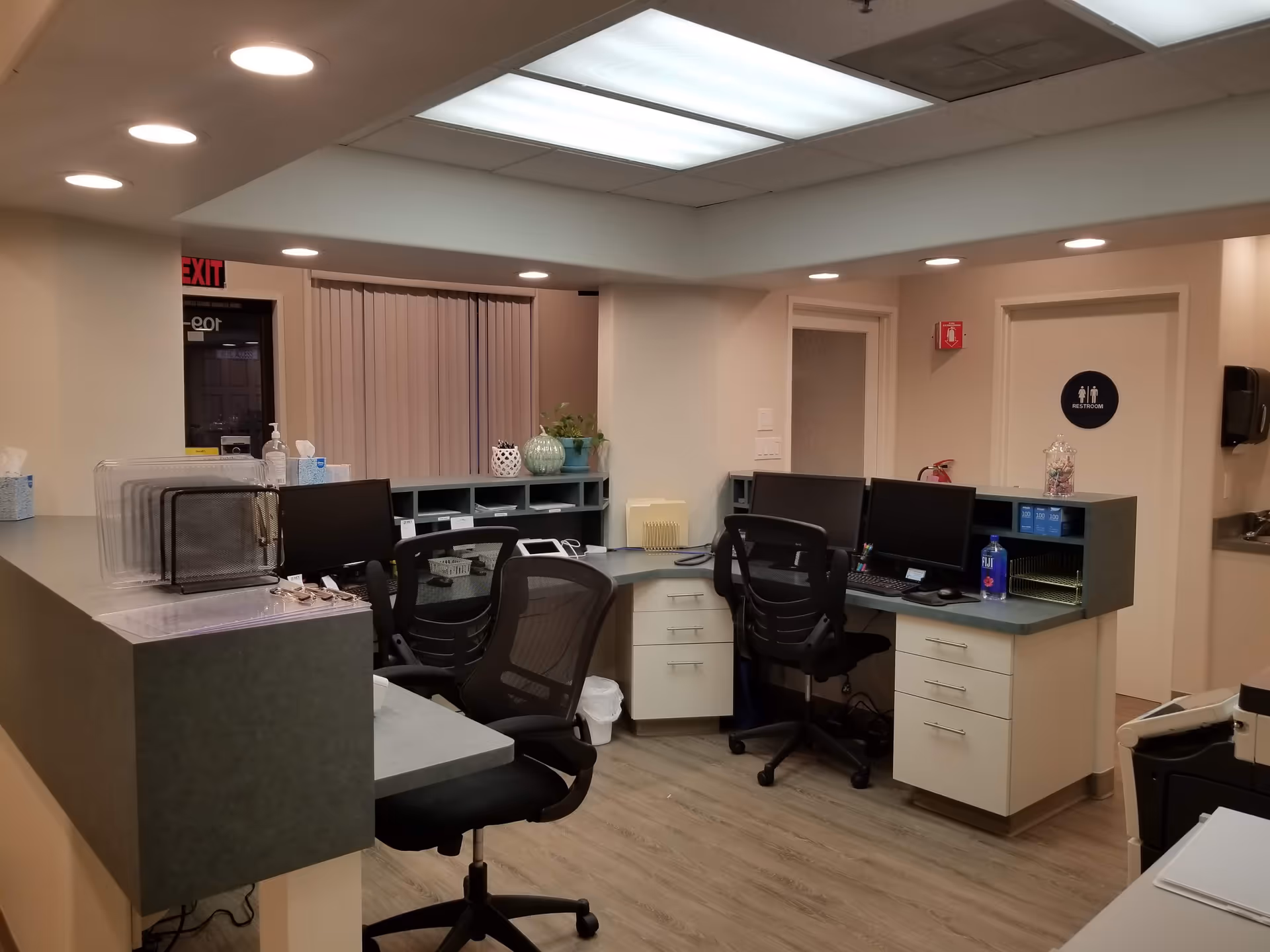 Reception area inside Comprehensive Medicine facility with desks, chairs, and computer workstations.