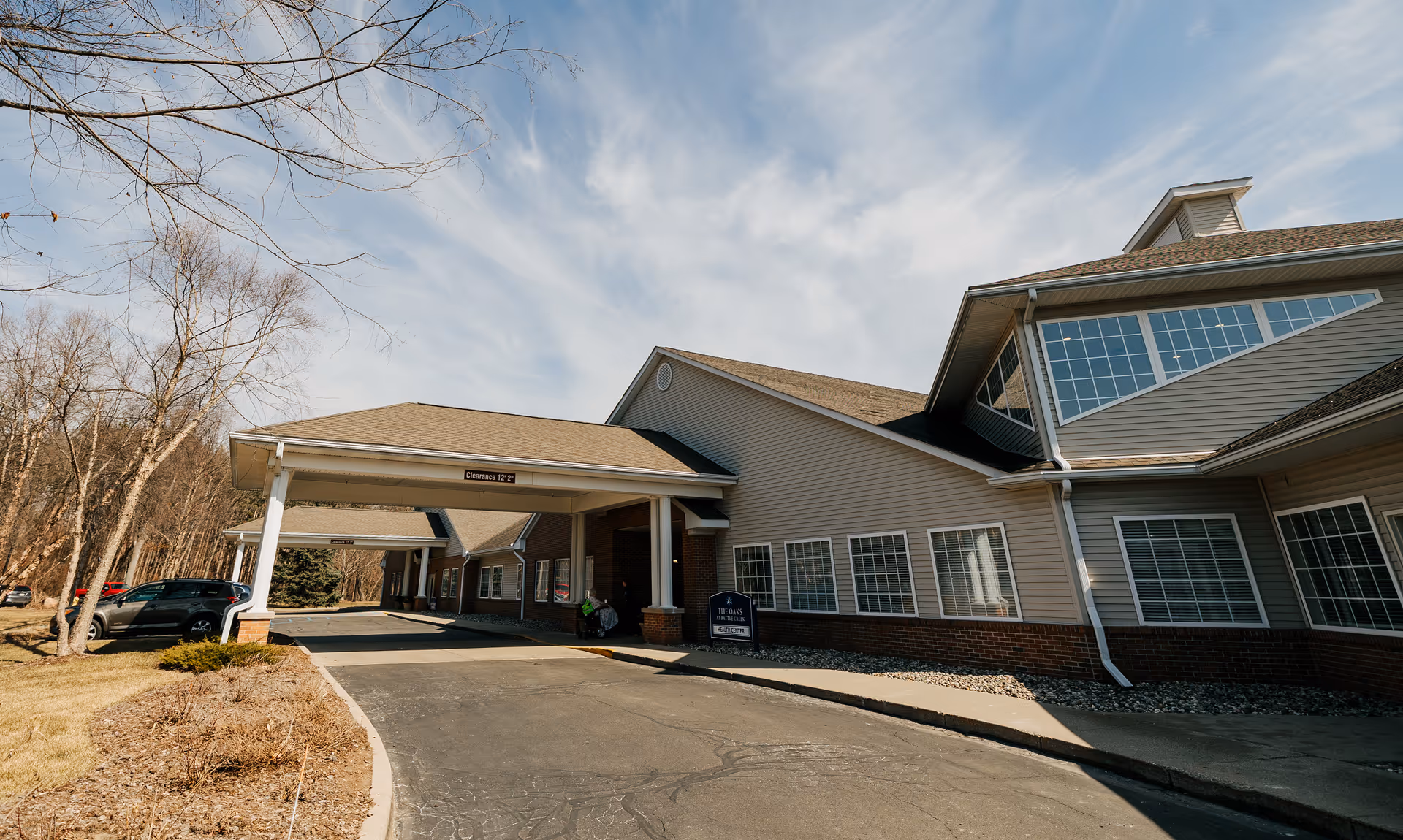 Front exterior view of The Oaks at North Pointe Woods with a covered entrance.