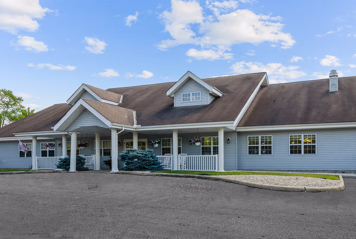 Front exterior view of Cedar Creek of Logansport, a blue single-story senior living facility.