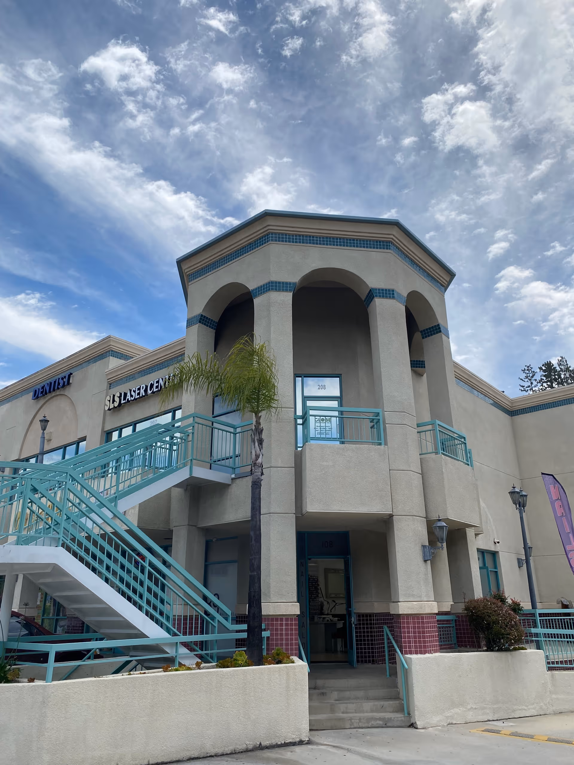 Exterior view of Globe Home Health Care, Inc. building with teal railings and a palm tree.