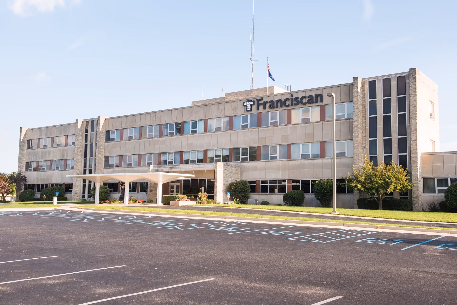 Exterior view of a multi-story senior living building with a covered entrance and parking lot.