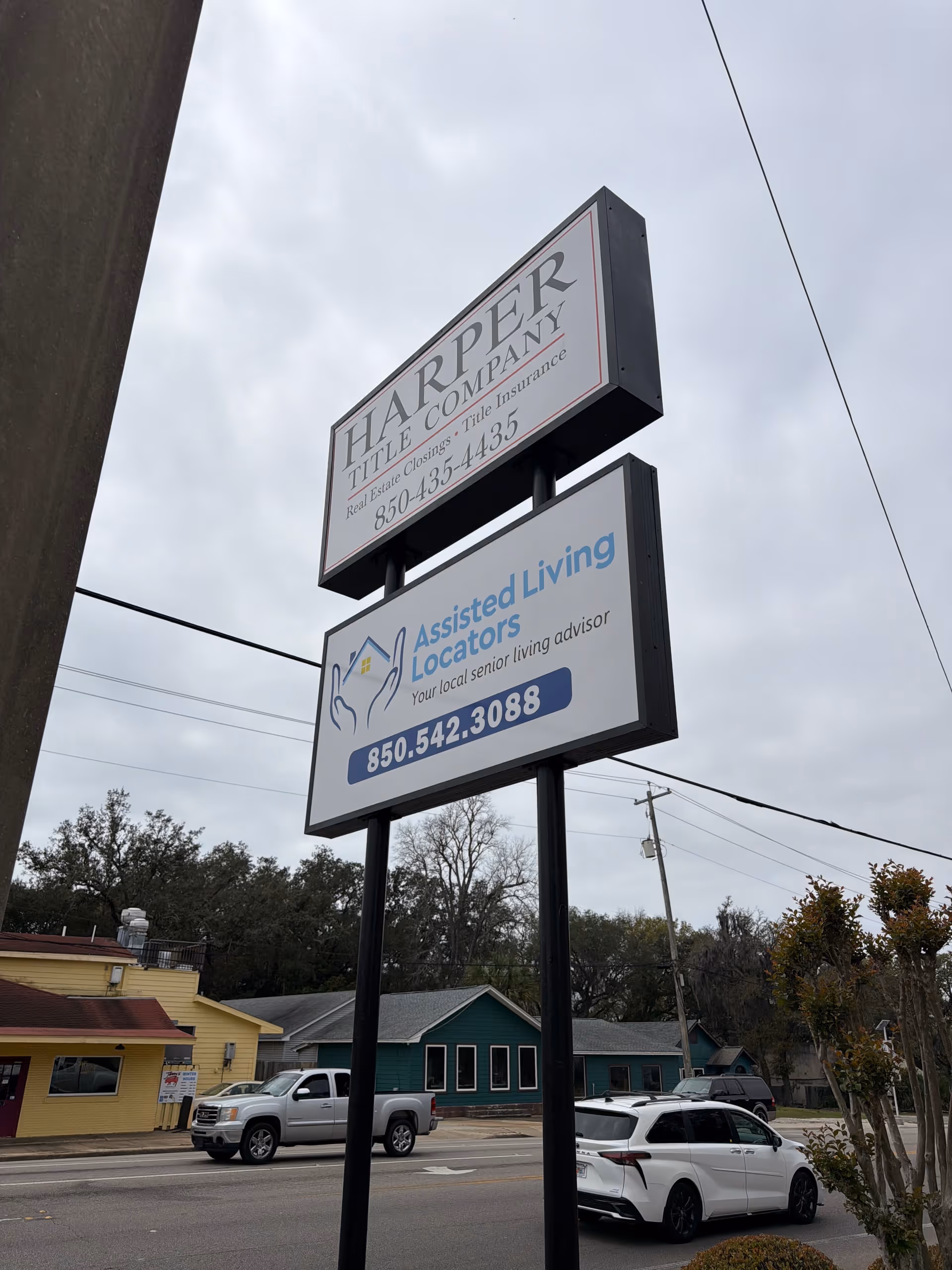 Street view with tall sign for Harper Tile Company and Assisted Living Locators.