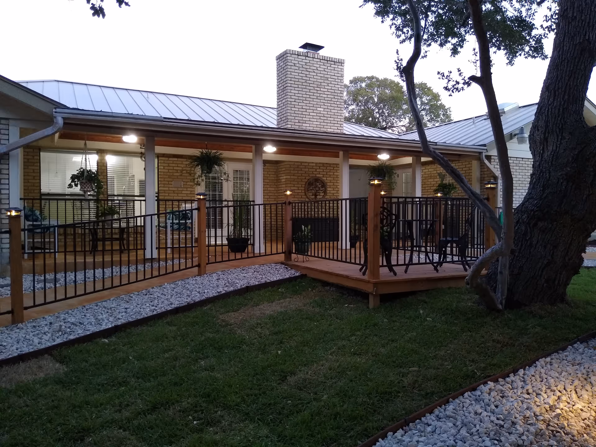 Exterior view of a brick building with a covered outdoor deck and patio seating.