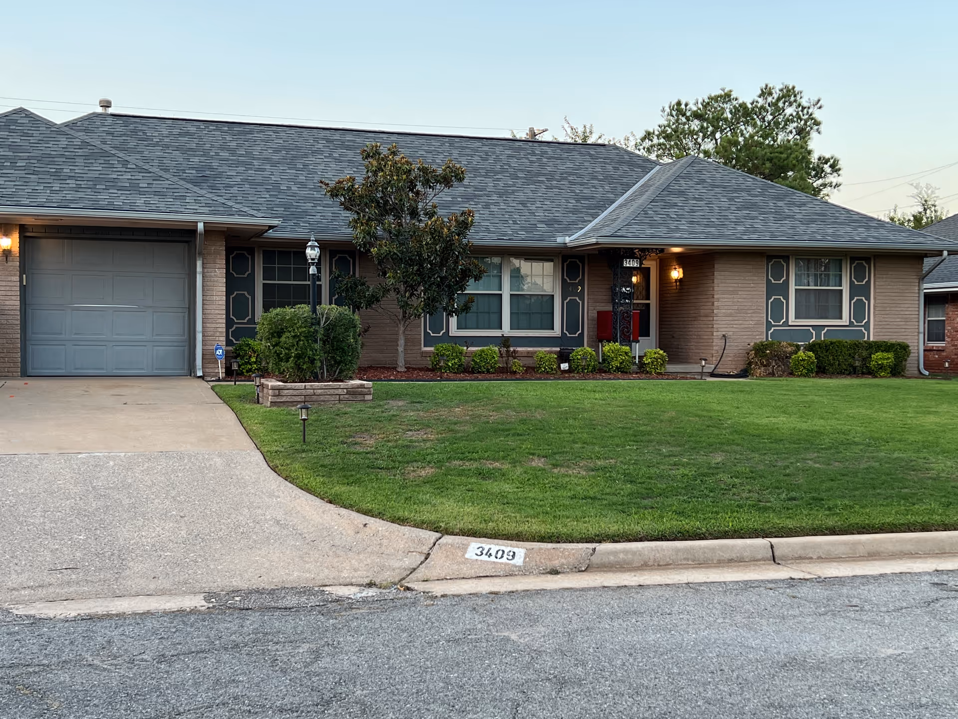 Front view of a single-story house with a manicured lawn and driveway