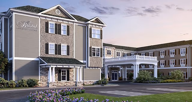 Front exterior view of The Bristal Assisted Living at West Babylon with entrance and landscaping.