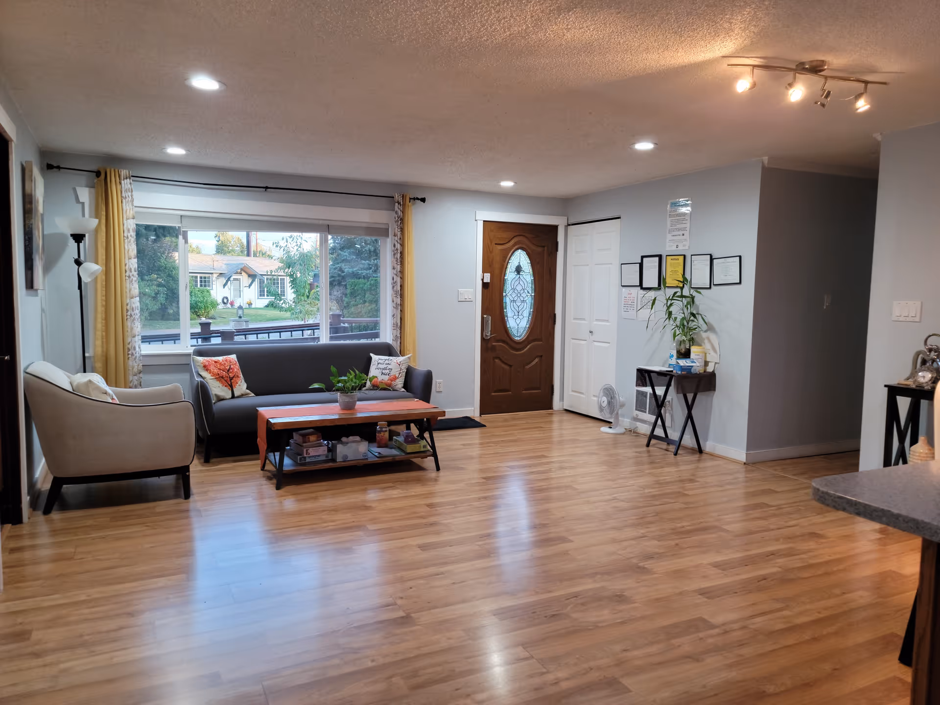 Open living area at Manor Adult Family Home with sofas, coffee table, and window view.